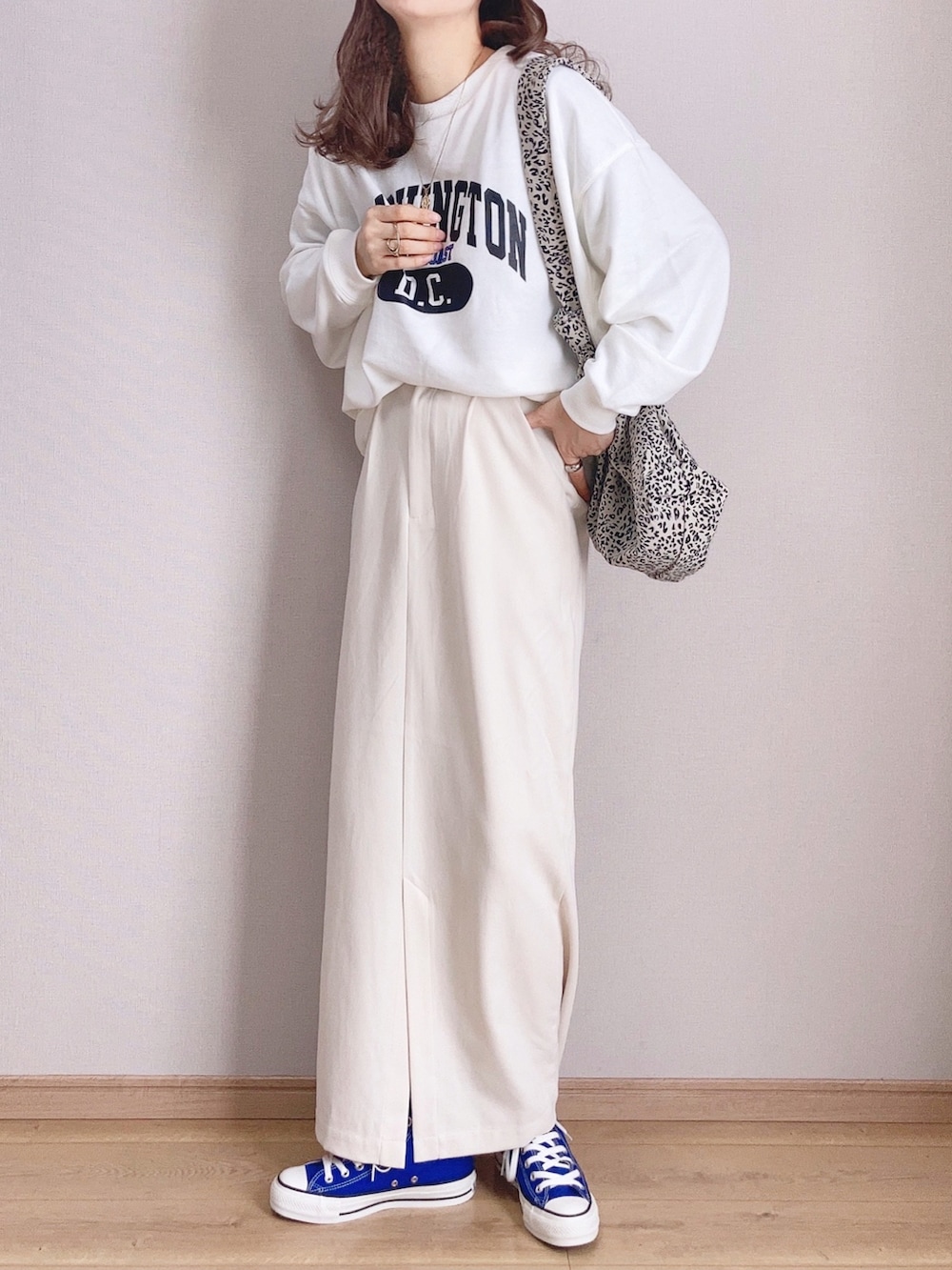 ホワイト系のスウェット、ブラック系のショルダーバッグ、ホワイト系のスカートを着用したレディースの冬コーディネートの2枚目の写真