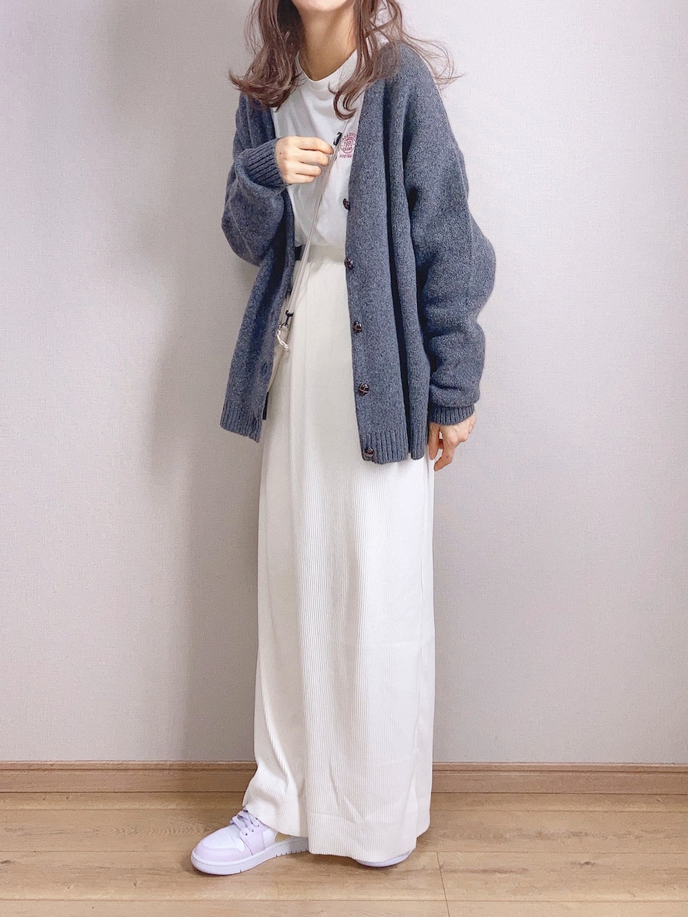 グレー系のカーディガン/ボレロ、ホワイト系のスカート、パープル系のスニーカーを着用したレディースの冬コーディネートの2枚目の写真