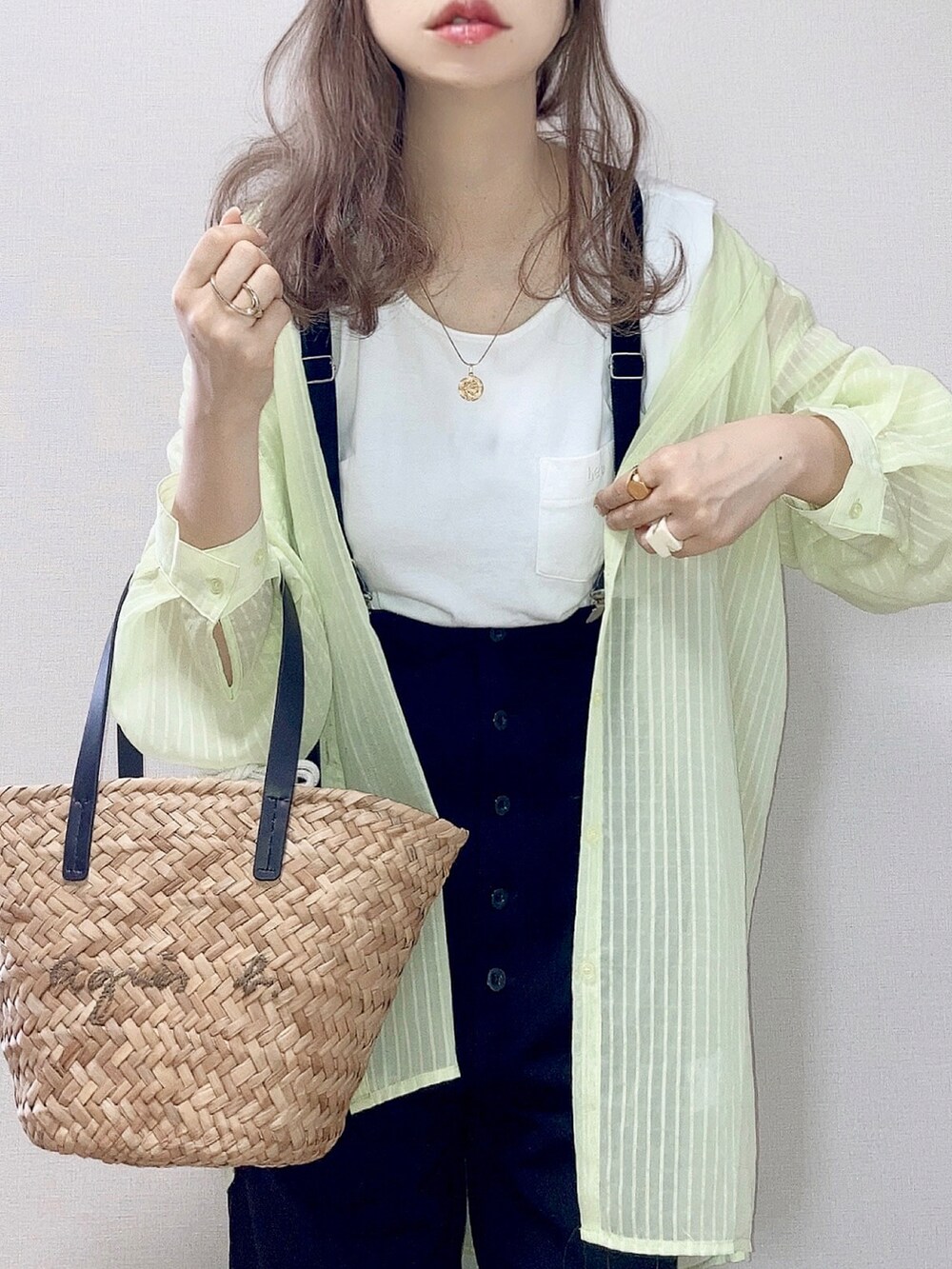 ブラック系のかごバッグ、ホワイト系のTシャツ/カットソー、グリーン系のシャツ/ブラウスを着用したレディースの夏コーディネートの2枚目の写真