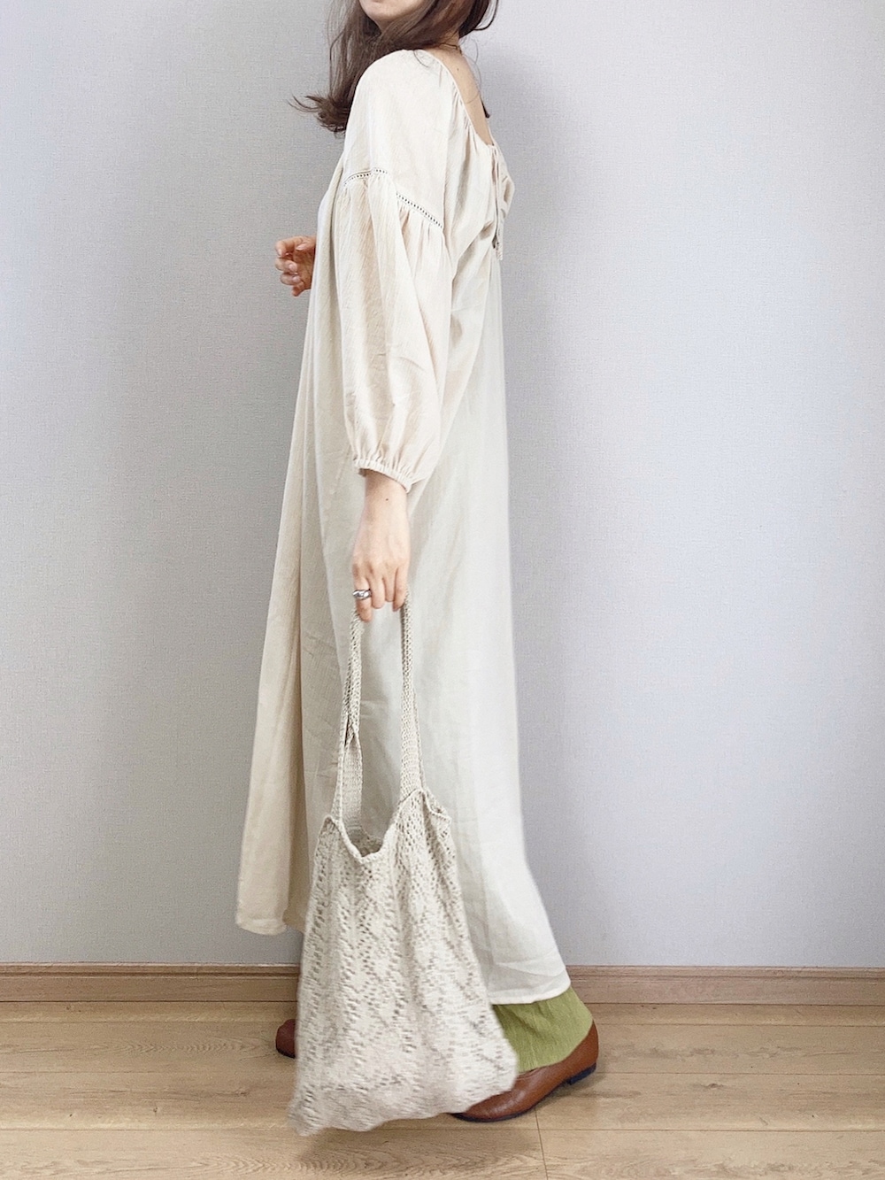 ホワイト系のワンピース、ホワイト系のトートバッグ、ブラウン系のパンプスを着用したレディースの春コーディネートの2枚目の写真