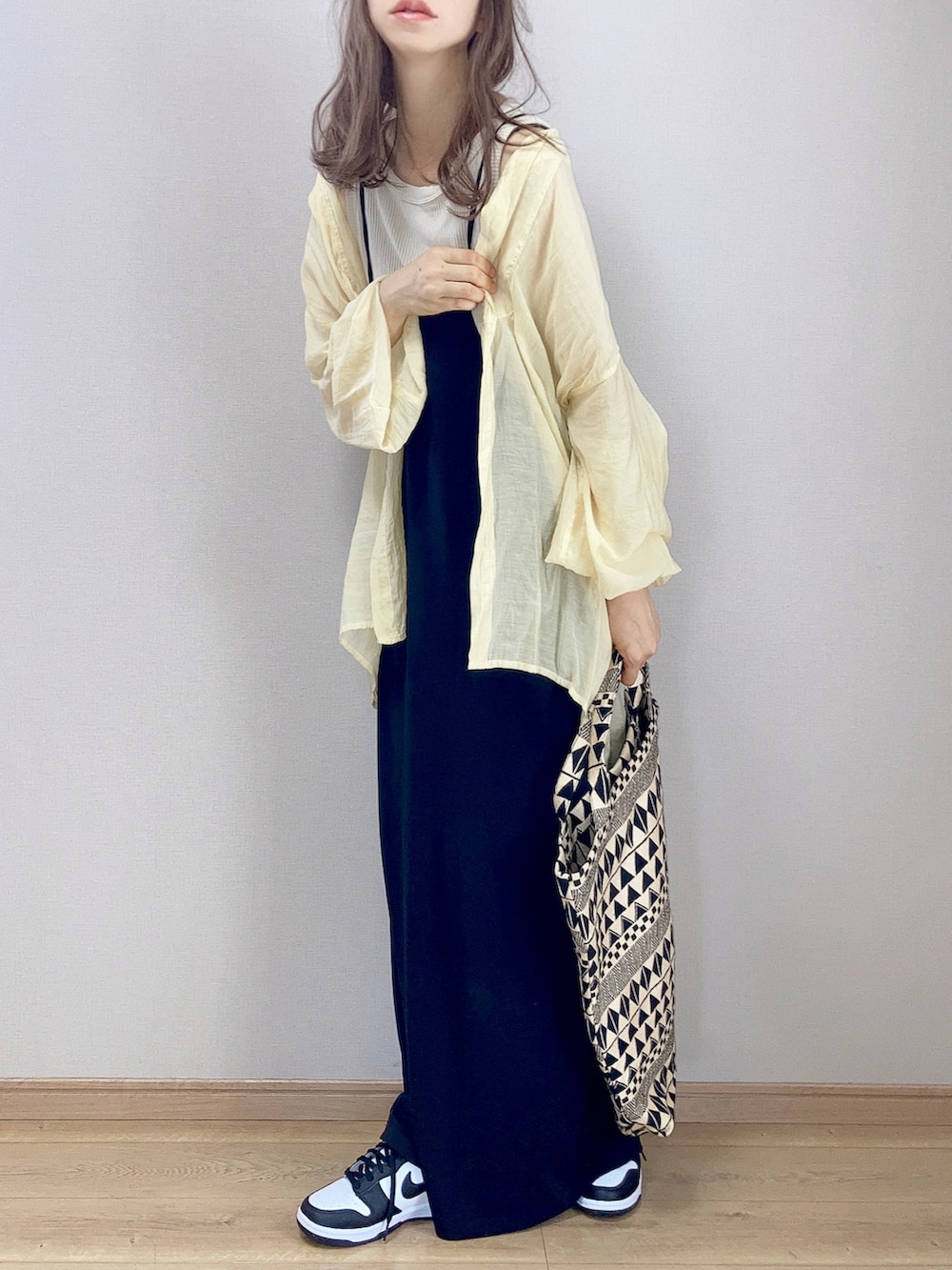 ブラック系のワンピース、ブラック系のショルダーバッグ、ホワイト系のスニーカーを着用したレディースの秋コーディネートの2枚目の写真