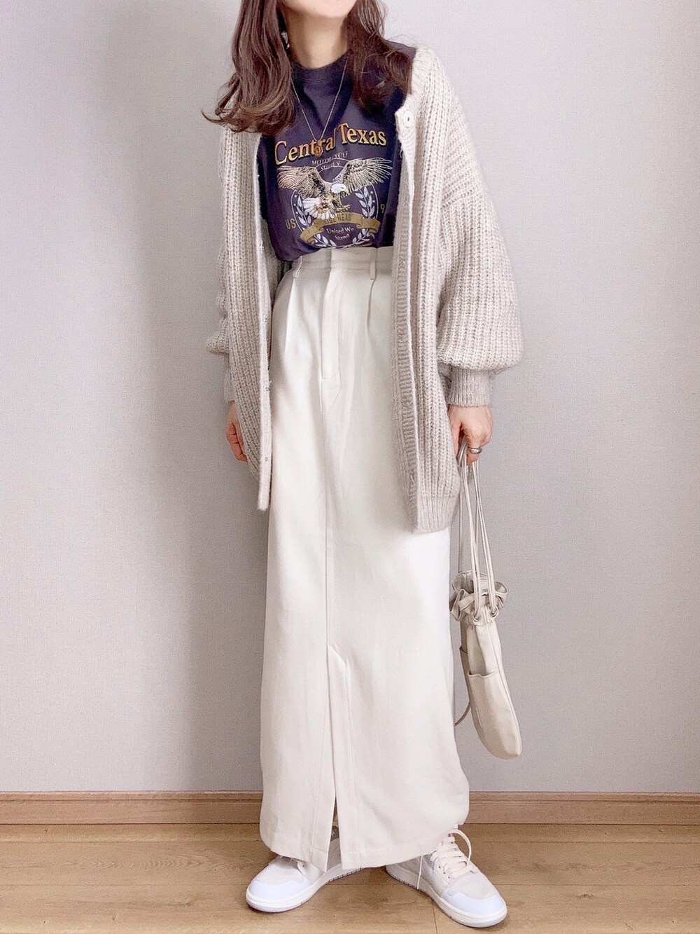 ブラック系のTシャツ/カットソー、ホワイト系のカーディガン/ボレロ、ホワイト系のスカートを着用したレディースの冬コーディネートの3枚目の写真