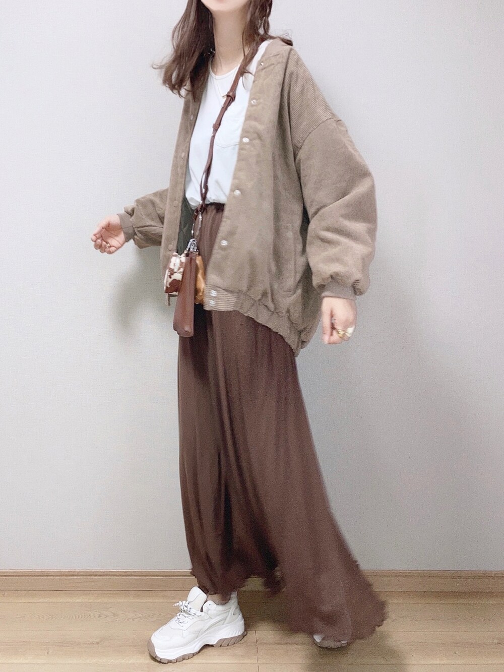 ブラウン系のスカート、ブラウン系のMA-1、ホワイト系のTシャツ/カットソーを着用したレディースの夏コーディネートの2枚目の写真