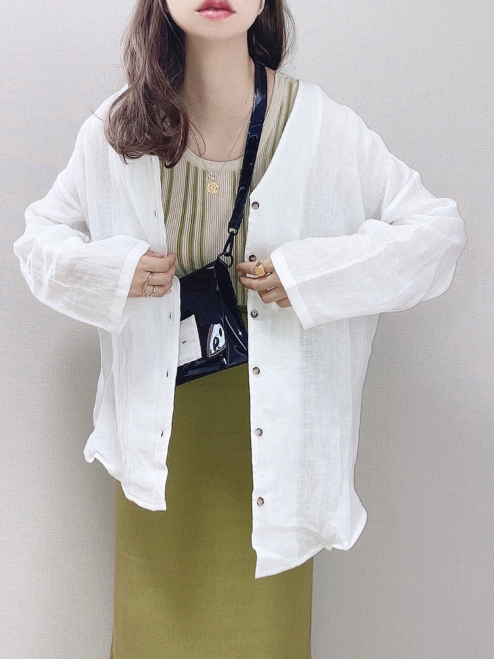 ホワイト系のシャツ/ブラウス、グリーン系のタンクトップ、グリーン系のスカートを着用したレディースの春コーディネートの2枚目の写真