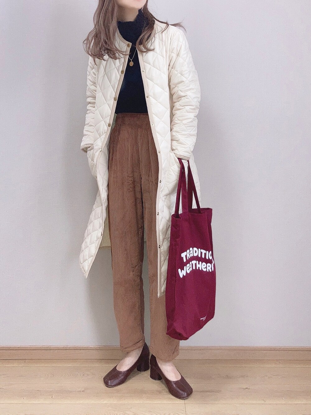 ホワイト系のその他アウター、ブラック系のニット/セーター、ブラウン系のその他パンツを着用したレディースの冬コーディネートの2枚目の写真