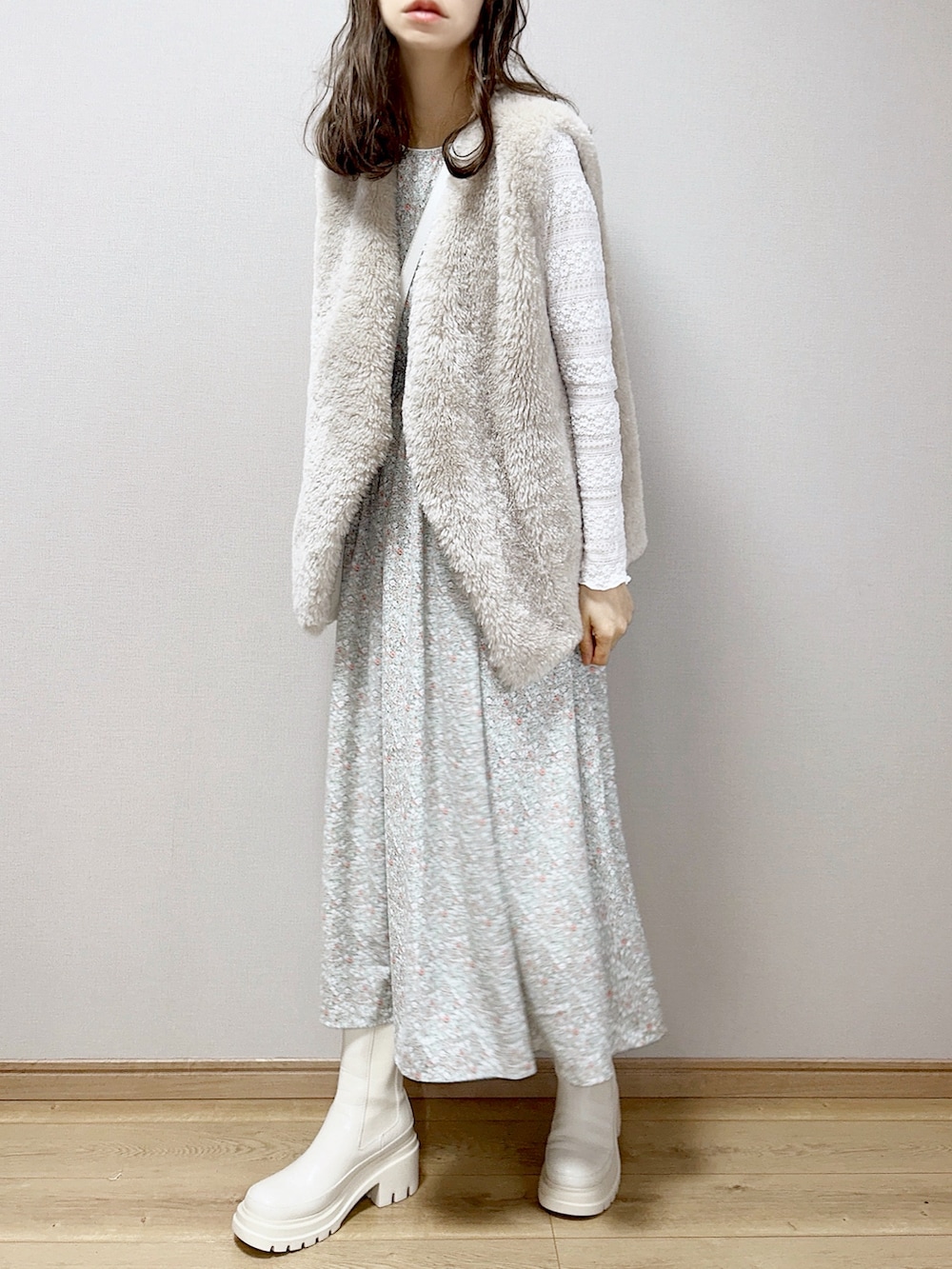 グリーン系のワンピース、グレー系のベスト、ホワイト系のTシャツ/カットソーを着用したレディースの冬コーディネートの2枚目の写真