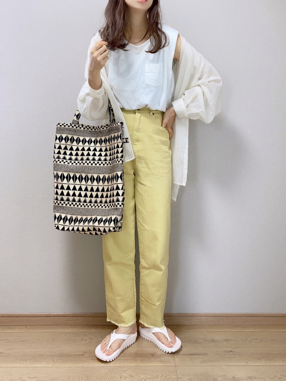 イエロー系のデニムパンツ、ホワイト系のシャツ/ブラウス、ブラック系のショルダーバッグを着用したレディースの夏コーディネートの2枚目の写真