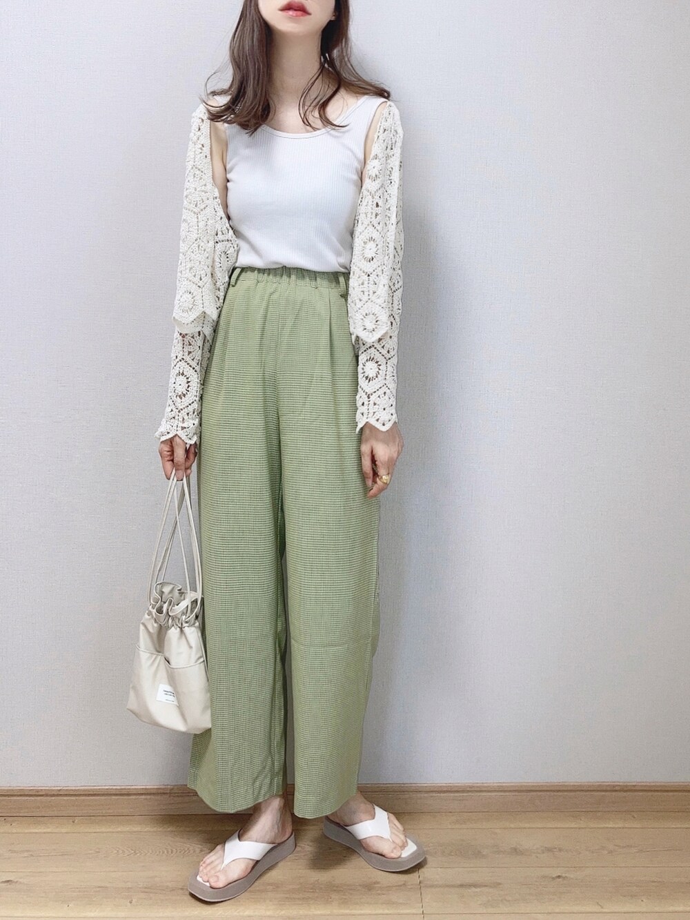 グリーン系のその他パンツ、ホワイト系のカーディガン/ボレロ、ホワイト系のタンクトップを着用したレディースの夏コーディネートの3枚目の写真