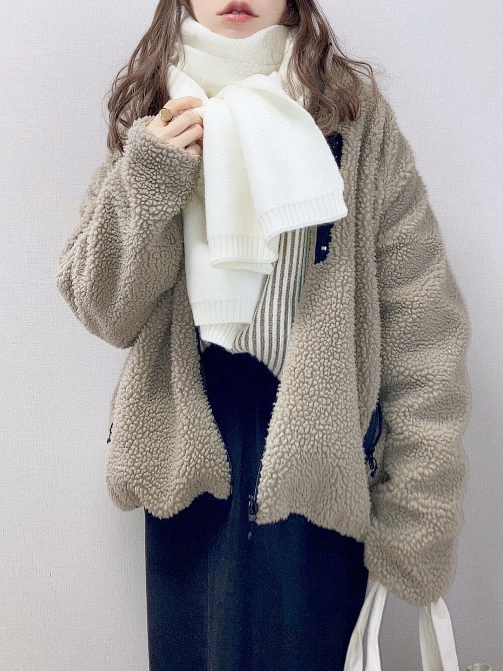 ベージュ系のブルゾン、ブラウン系のニット/セーター、ブラック系のスカートを着用したレディースの冬コーディネートの3枚目の写真