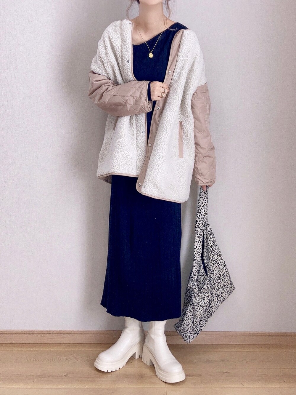 ベージュ系のブーツ、ベージュ系のノーカラージャケット、ブラック系のワンピースを着用したレディースの秋コーディネートの2枚目の写真