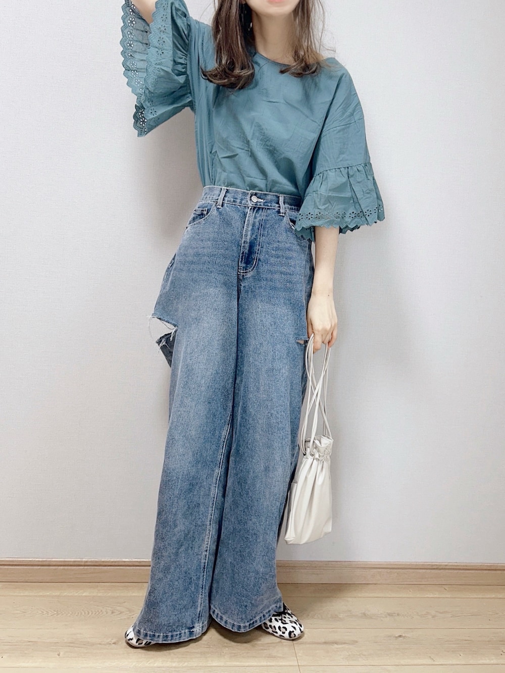 グリーン系のシャツ/ブラウス、ブルー系のデニムパンツ、ベージュ系のショルダーバッグを着用したレディースの春コーディネートの2枚目の写真