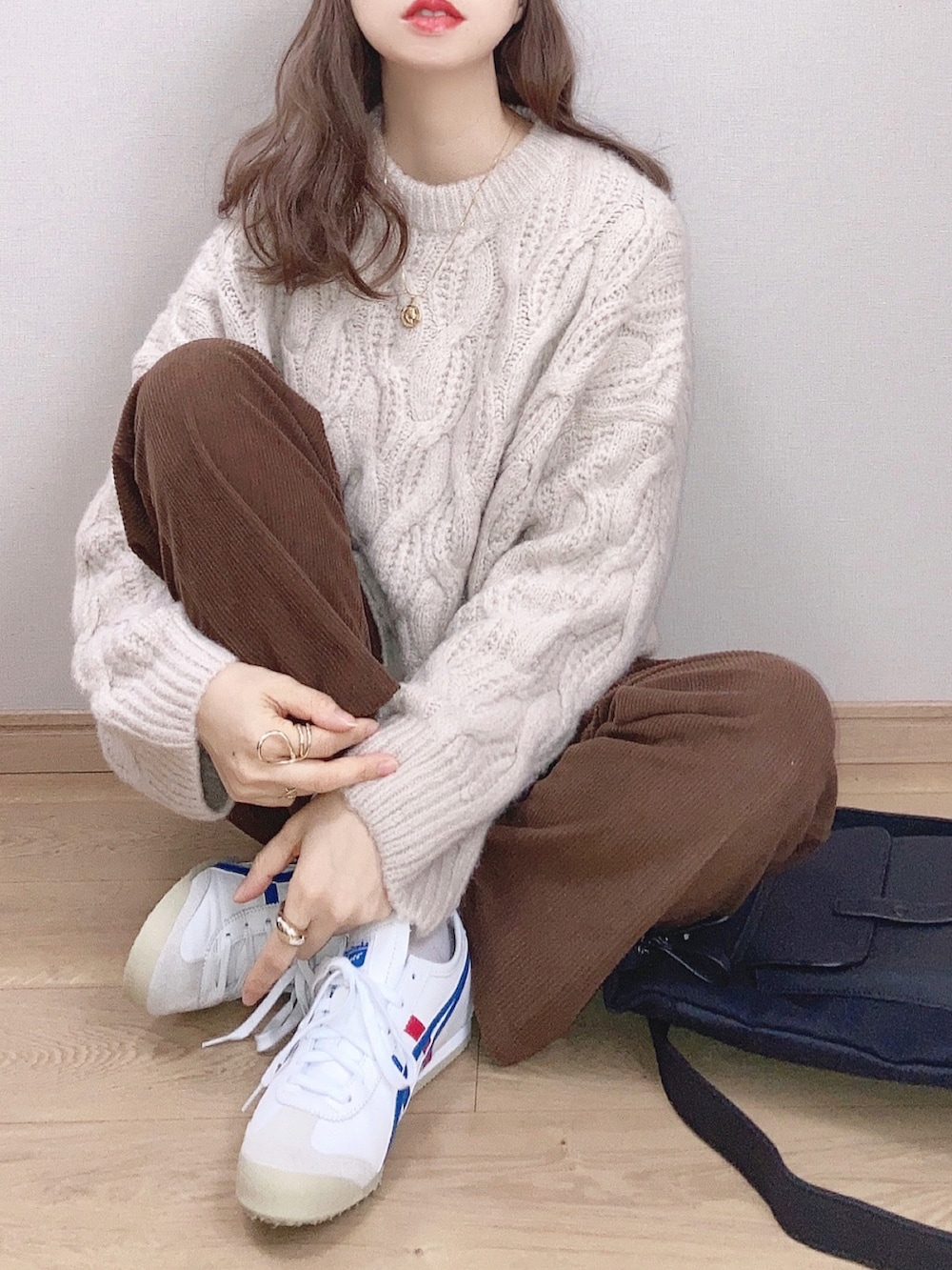 ホワイト系のスニーカー、ホワイト系のニット/セーター、ブラウン系のその他パンツを着用したレディースの秋コーディネートの2枚目の写真