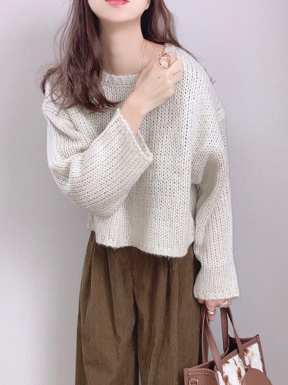 ホワイト系のニット/セーター、グリーン系のその他パンツ、ブラウン系のトートバッグを着用したレディースの秋コーディネートの2枚目の写真
