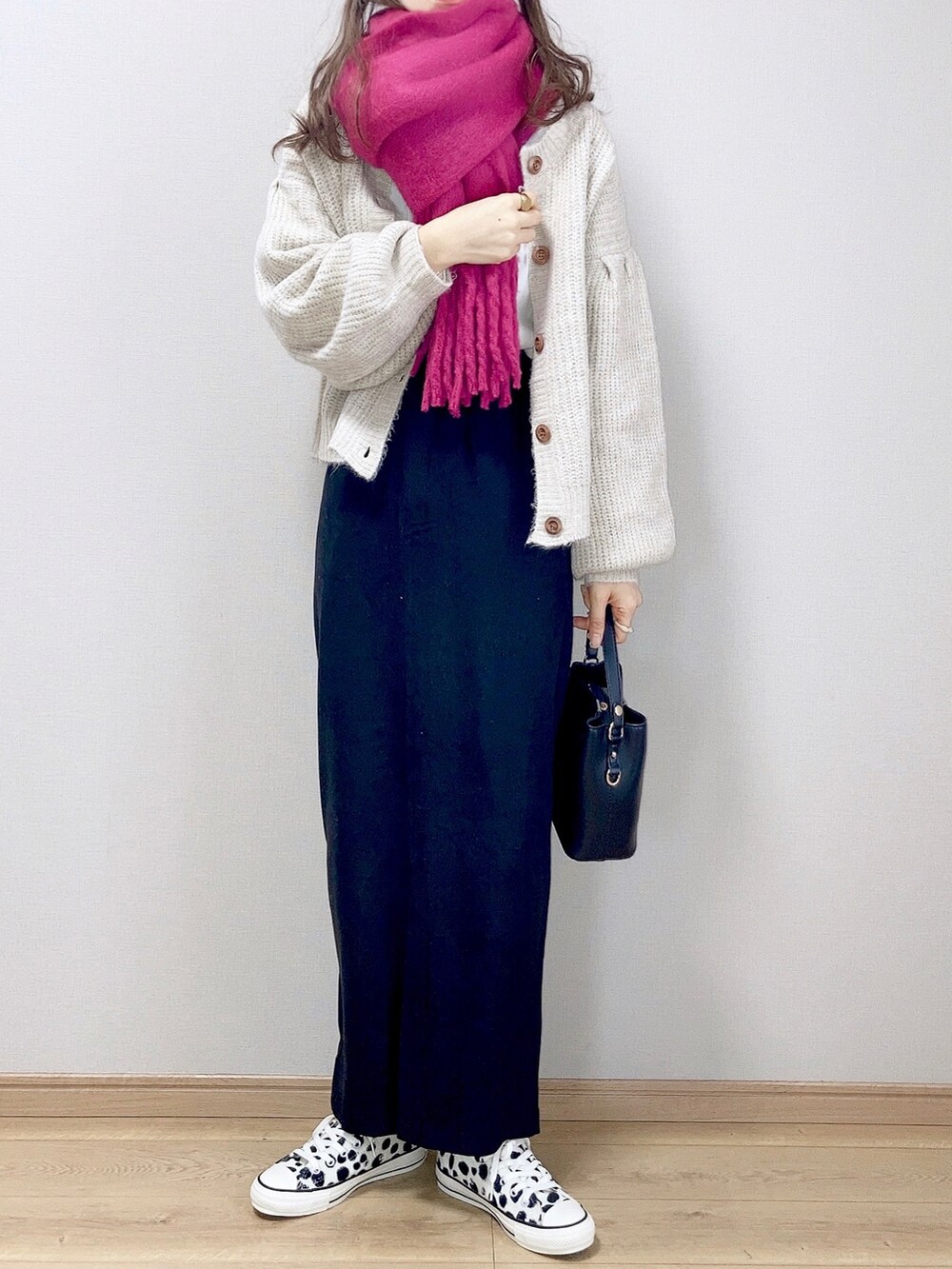 ホワイト系のカーディガン/ボレロ、ブラック系のショルダーバッグ、ブラック系のスカートを着用したレディースの冬コーディネートの2枚目の写真