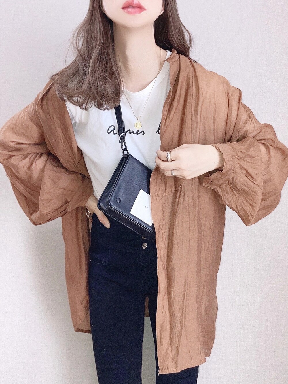 ホワイト系のTシャツ/カットソー、ブラウン系のシャツ/ブラウス、ブラック系のデニムパンツを着用したレディースの春コーディネートの2枚目の写真