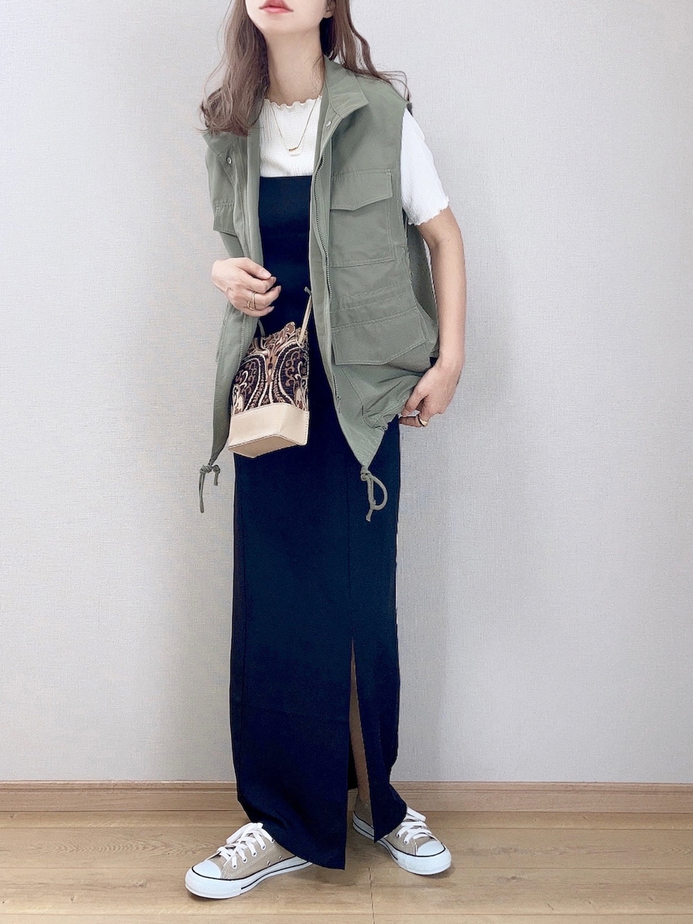 グリーン系のベスト、ホワイト系のTシャツ/カットソー、ブラック系のワンピースを着用したレディースの夏コーディネートの3枚目の写真