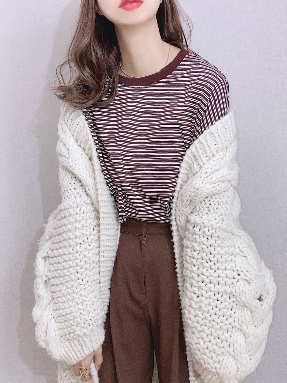 ブラウン系のTシャツ/カットソー、ホワイト系のカーディガン/ボレロ、ブラウン系のその他パンツを着用したレディースの冬コーディネートの2枚目の写真