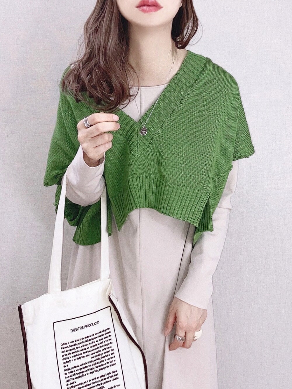 グリーン系のベスト、ベージュ系のワンピース、ベージュ系のトートバッグを着用したレディースの春コーディネートの2枚目の写真