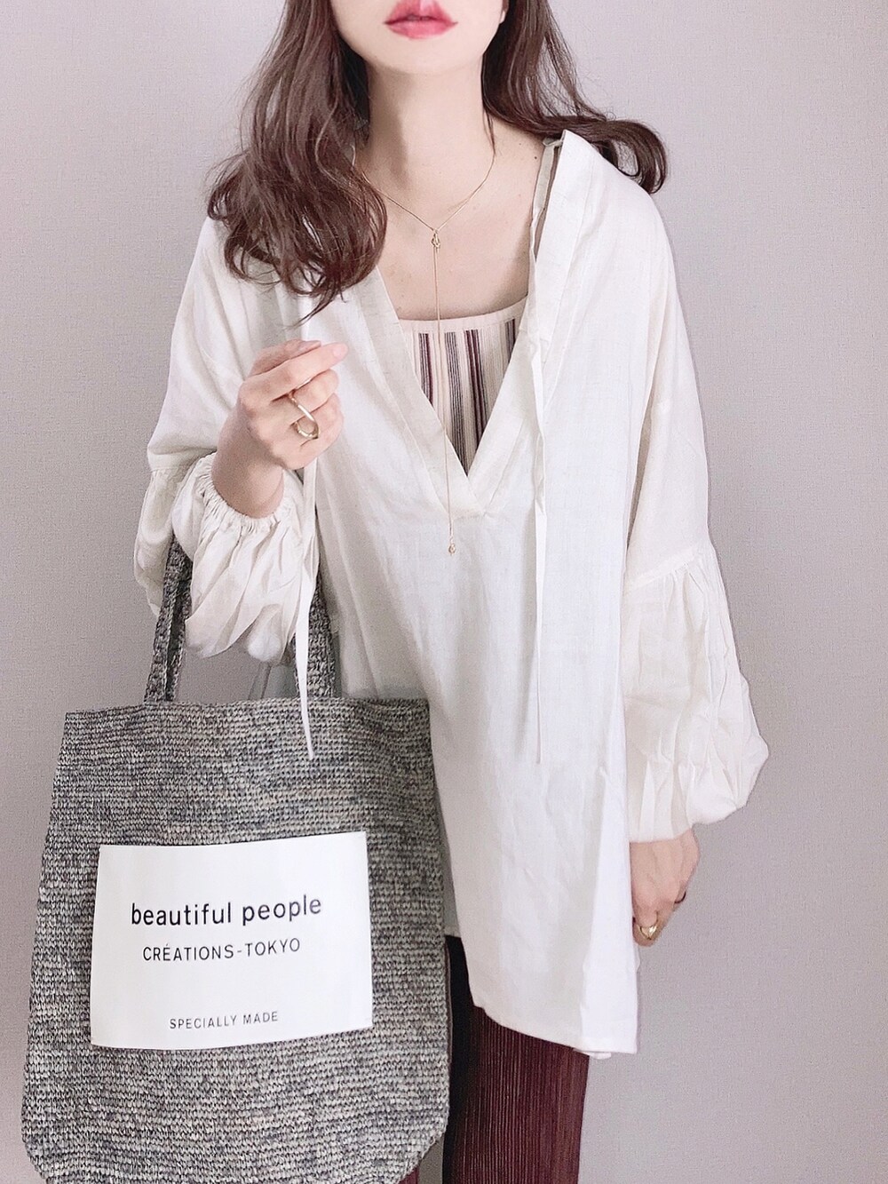 ベージュ系のシャツ/ブラウス、ブラウン系のその他パンツ、グレー系のトートバッグを着用したレディースの春コーディネートの2枚目の写真