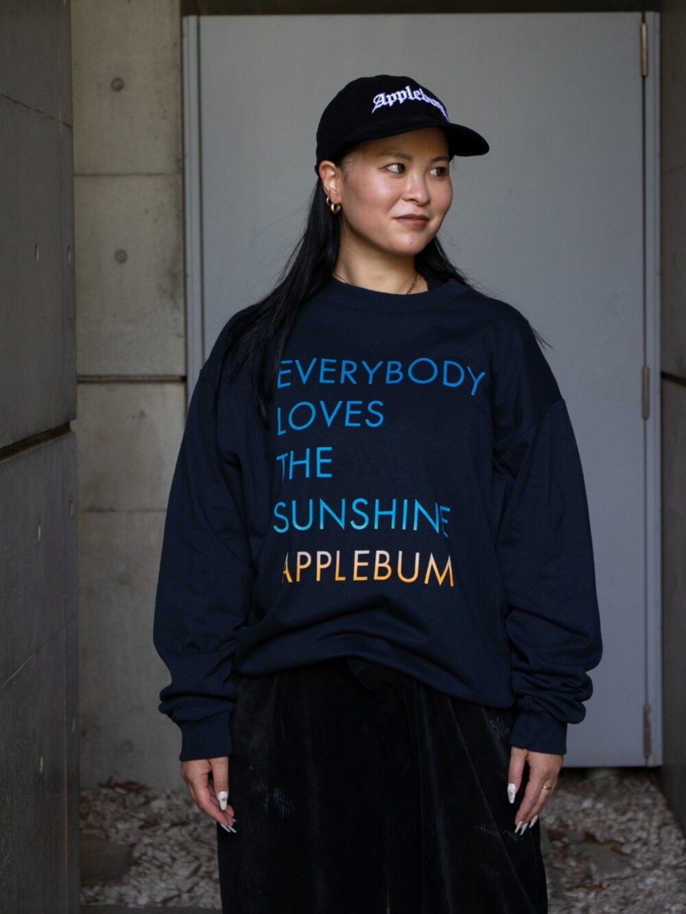 ブルー系のTシャツ/カットソー、ブラック系のキャップを着用したレディースの秋コーディネートの2枚目の写真