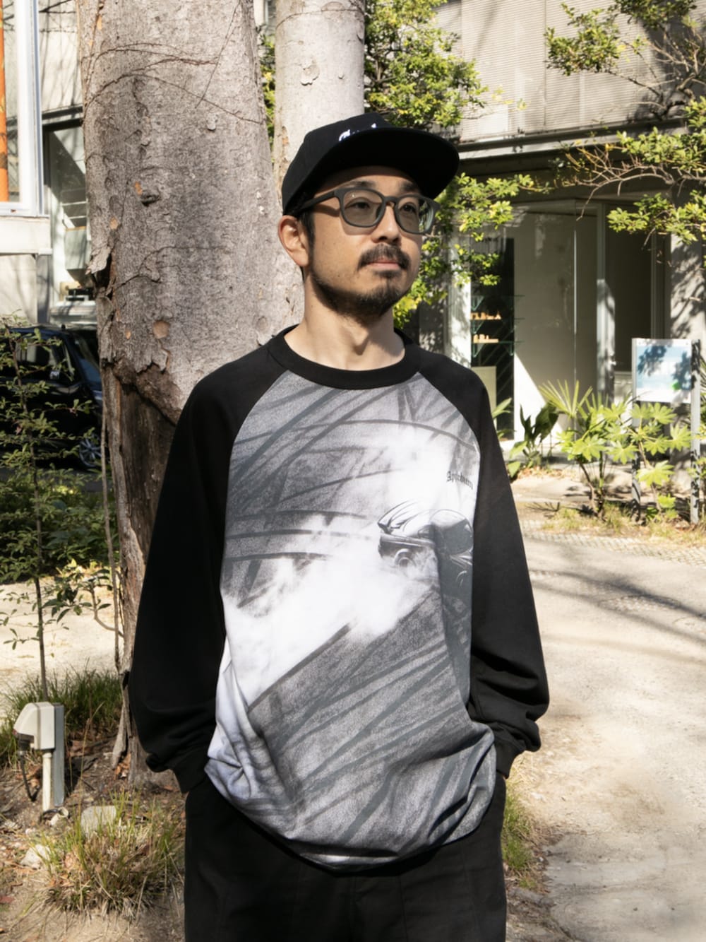 ブラック系のTシャツ/カットソーを着用したメンズの春コーディネートの2枚目の写真