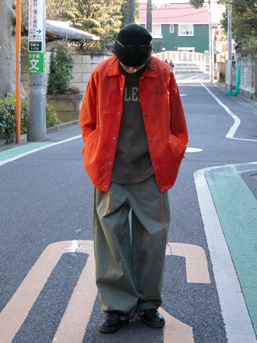 オレンジ系のブルゾン、ブラック系のその他パンツを着用したメンズの春コーディネートの2枚目の写真