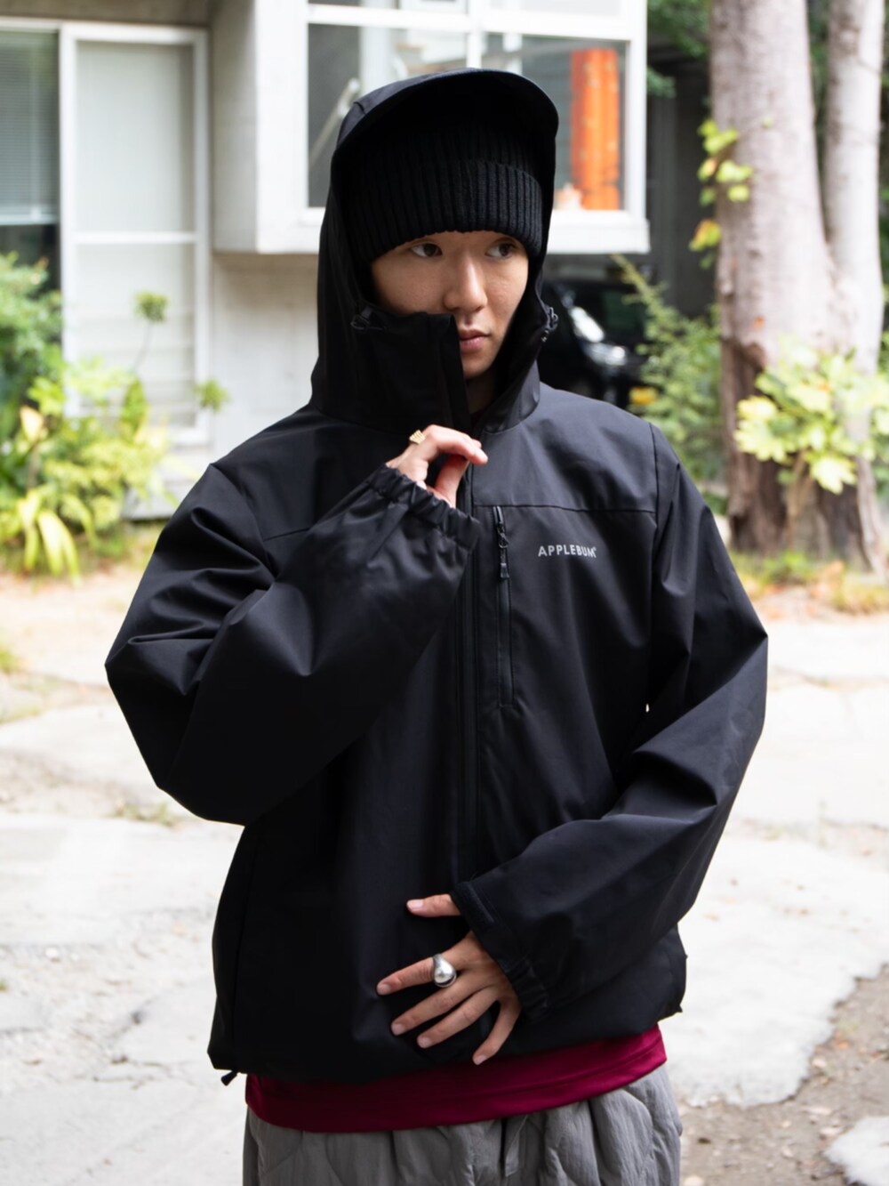 レッド系のTシャツ/カットソー、ブラック系のブルゾン、ブラック系のニットキャップ/ビーニーを着用したメンズの秋コーディネートの2枚目の写真