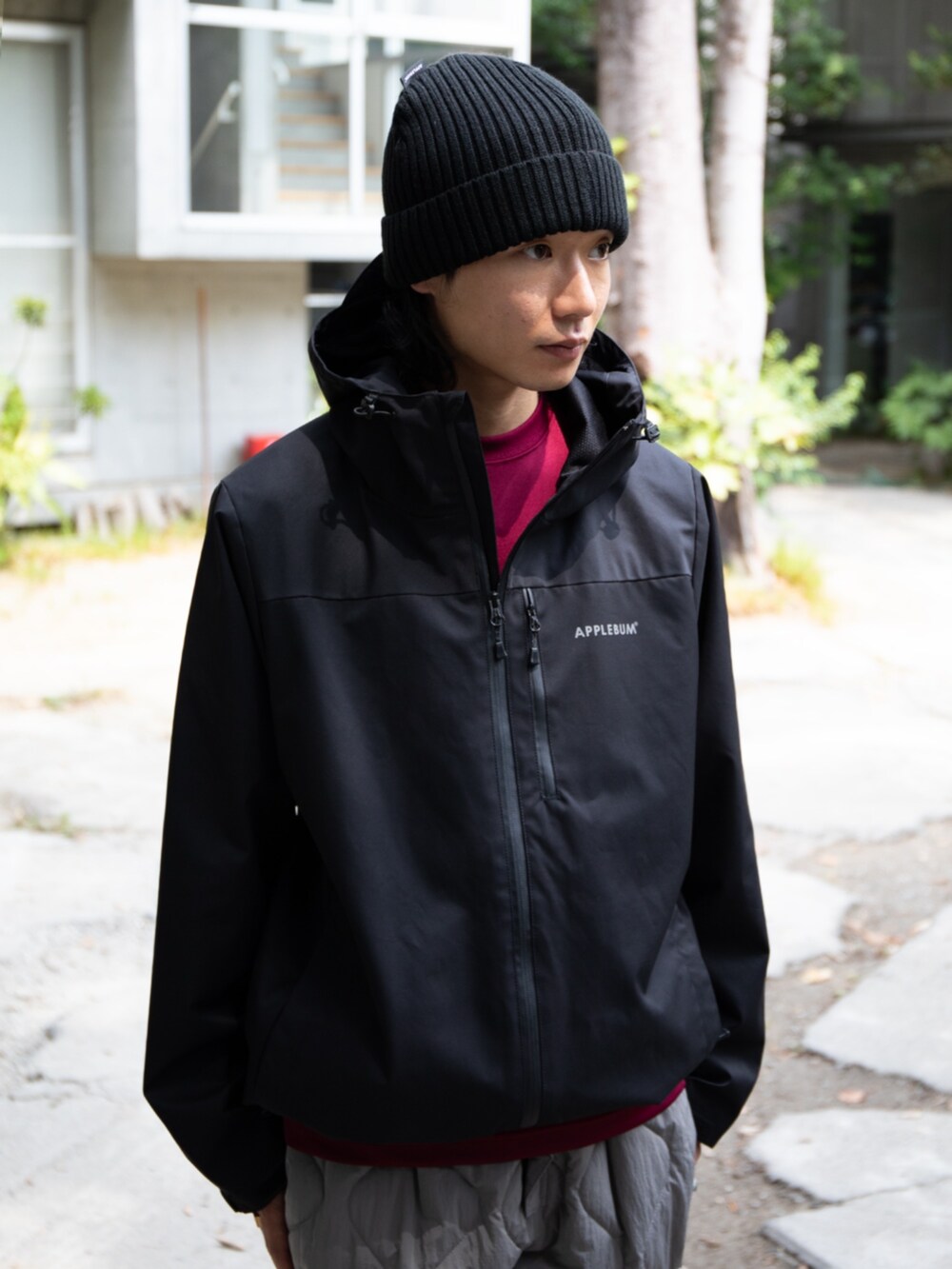 レッド系のTシャツ/カットソー、ブラック系のブルゾン、ブラック系のニットキャップ/ビーニーを着用したメンズの秋コーディネートの4枚目の写真