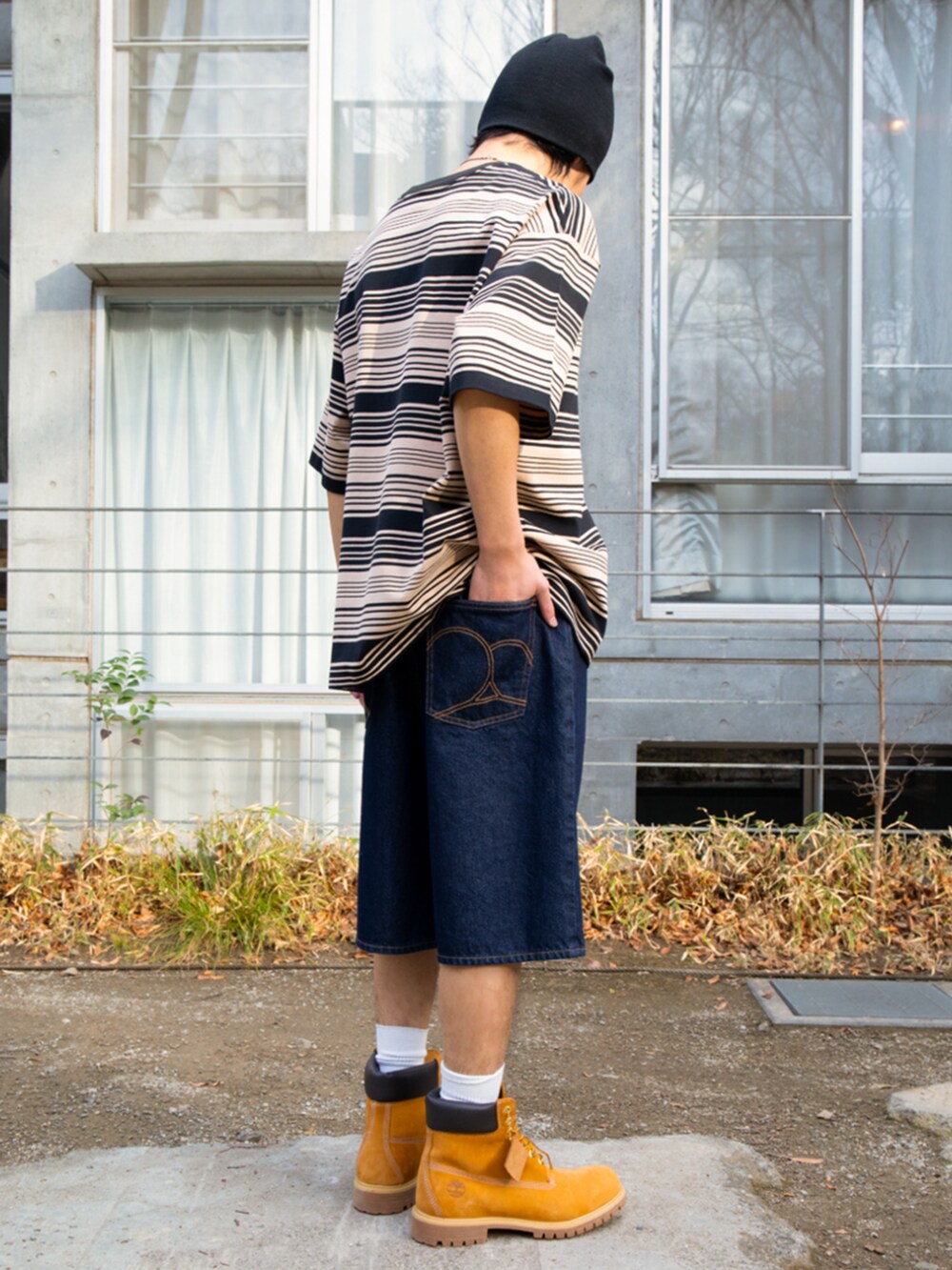 ブルー系のデニムパンツ、ベージュ系のTシャツ/カットソーを着用したメンズの夏コーディネートの3枚目の写真