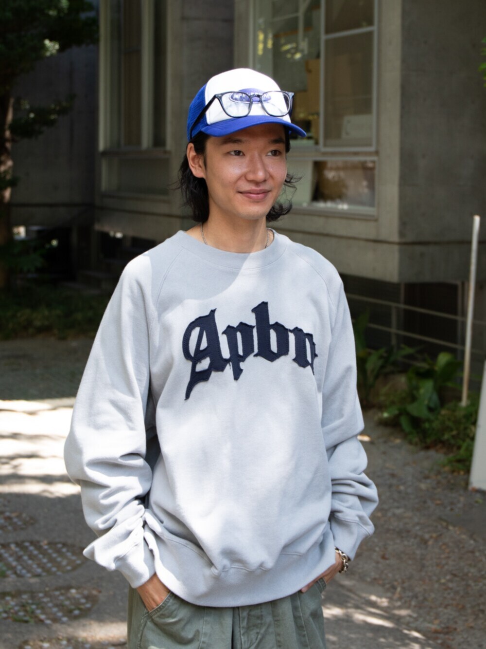 グレー系のスウェット、ブルー系のキャップを着用したメンズの秋コーディネートの2枚目の写真