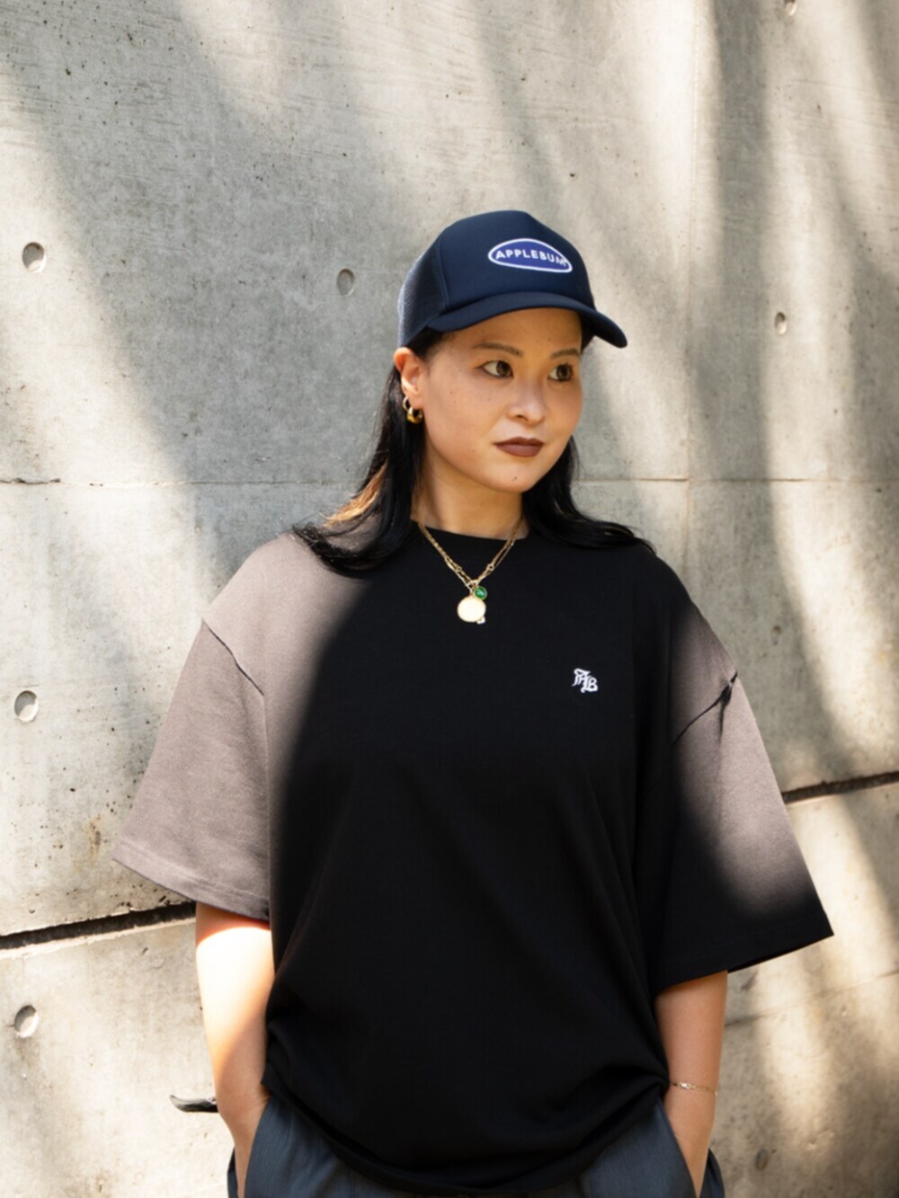 ブラック系のTシャツ/カットソー、グレー系のその他パンツ、ブルー系のキャップを着用したレディースの夏コーディネートの2枚目の写真