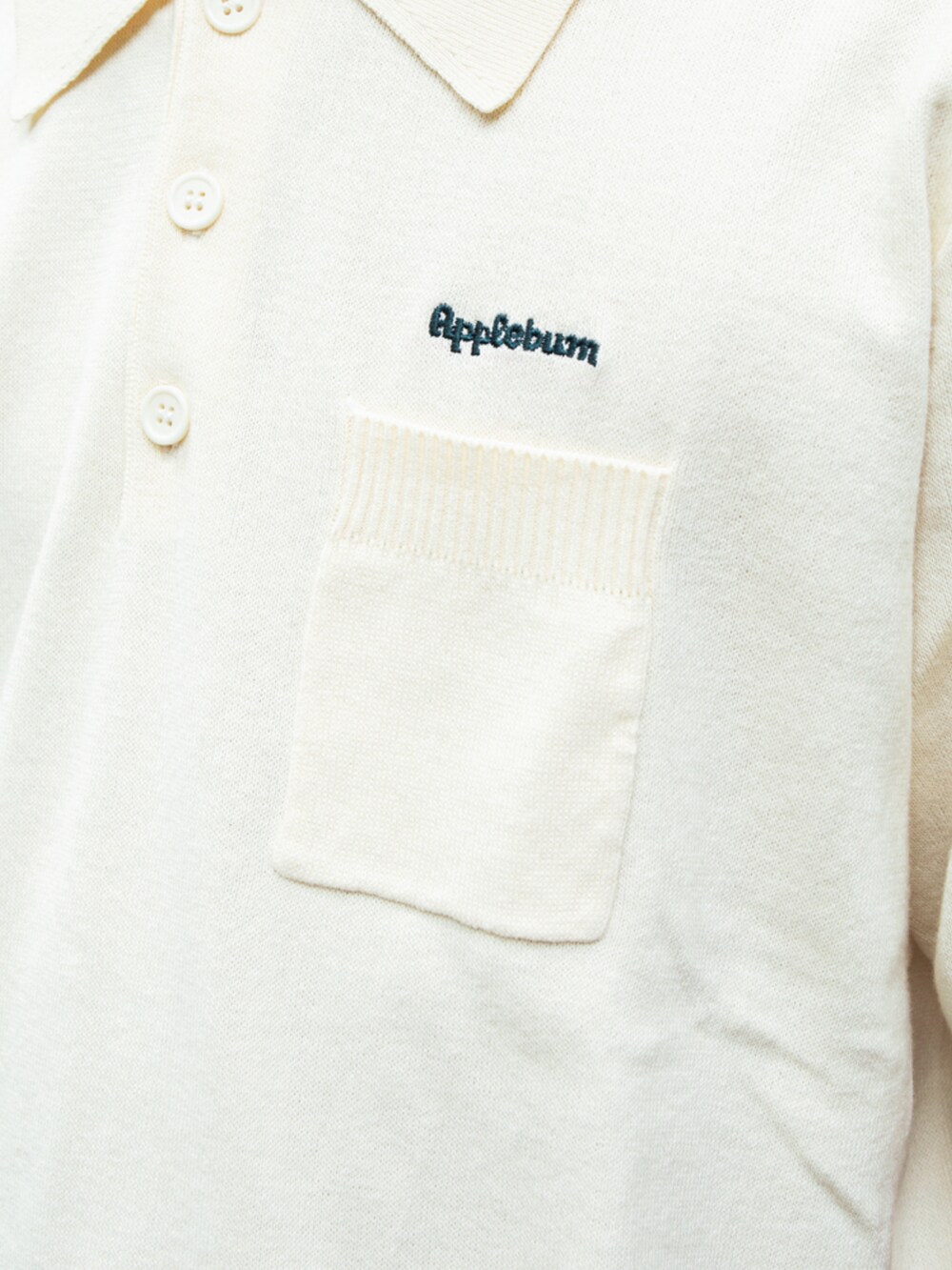 ベージュ系のポロシャツ、ブルー系のデニムパンツ、ホワイト系のキャップを着用したメンズの夏コーディネートの2枚目の写真