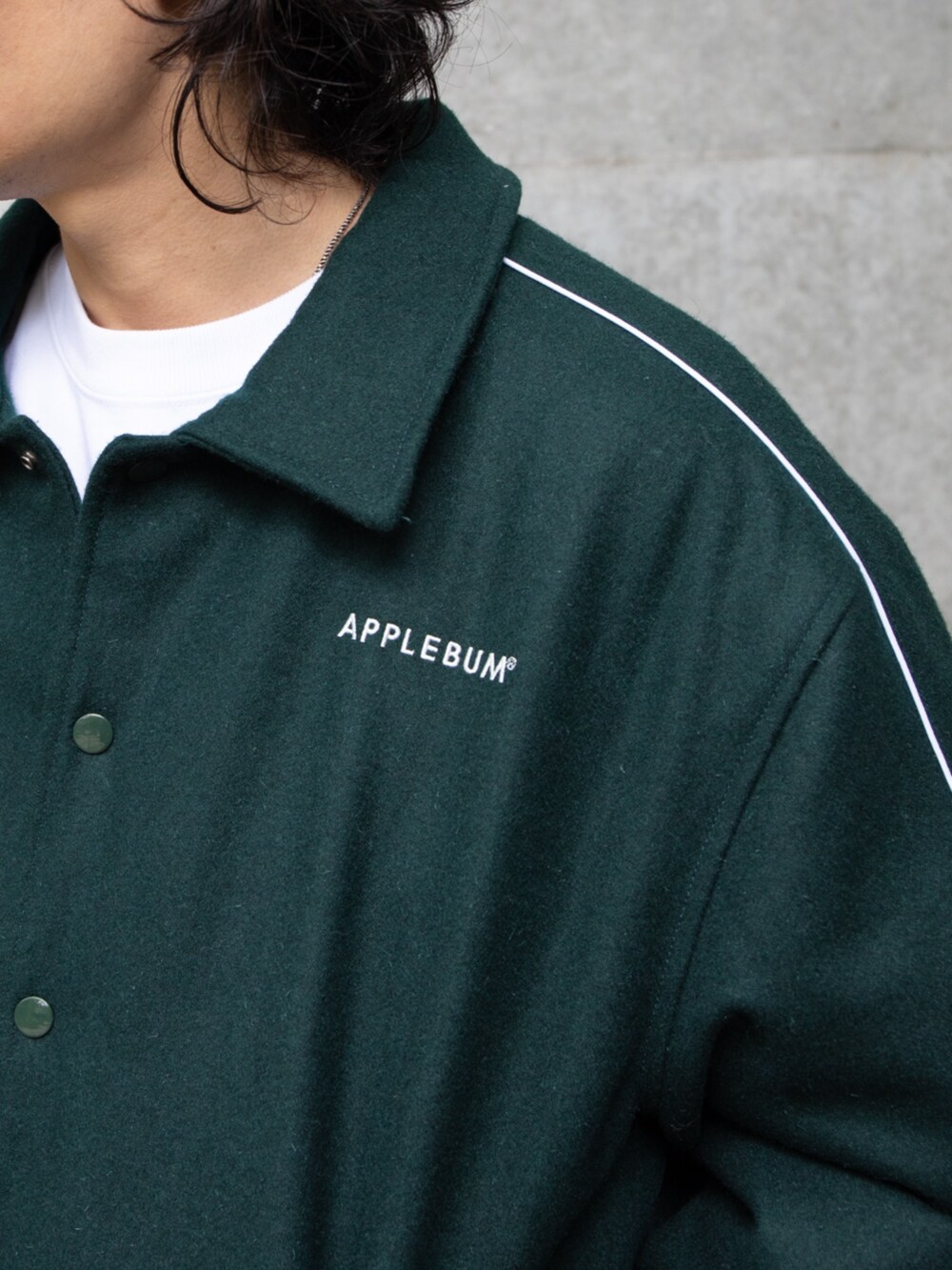 グリーン系のブルゾン、ブルー系のキャップを着用したメンズの秋コーディネートの3枚目の写真