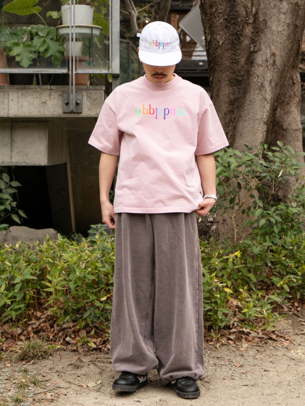 ブラック系のスウェットパンツ、ホワイト系のキャップを着用したメンズの春コーディネートの2枚目の写真