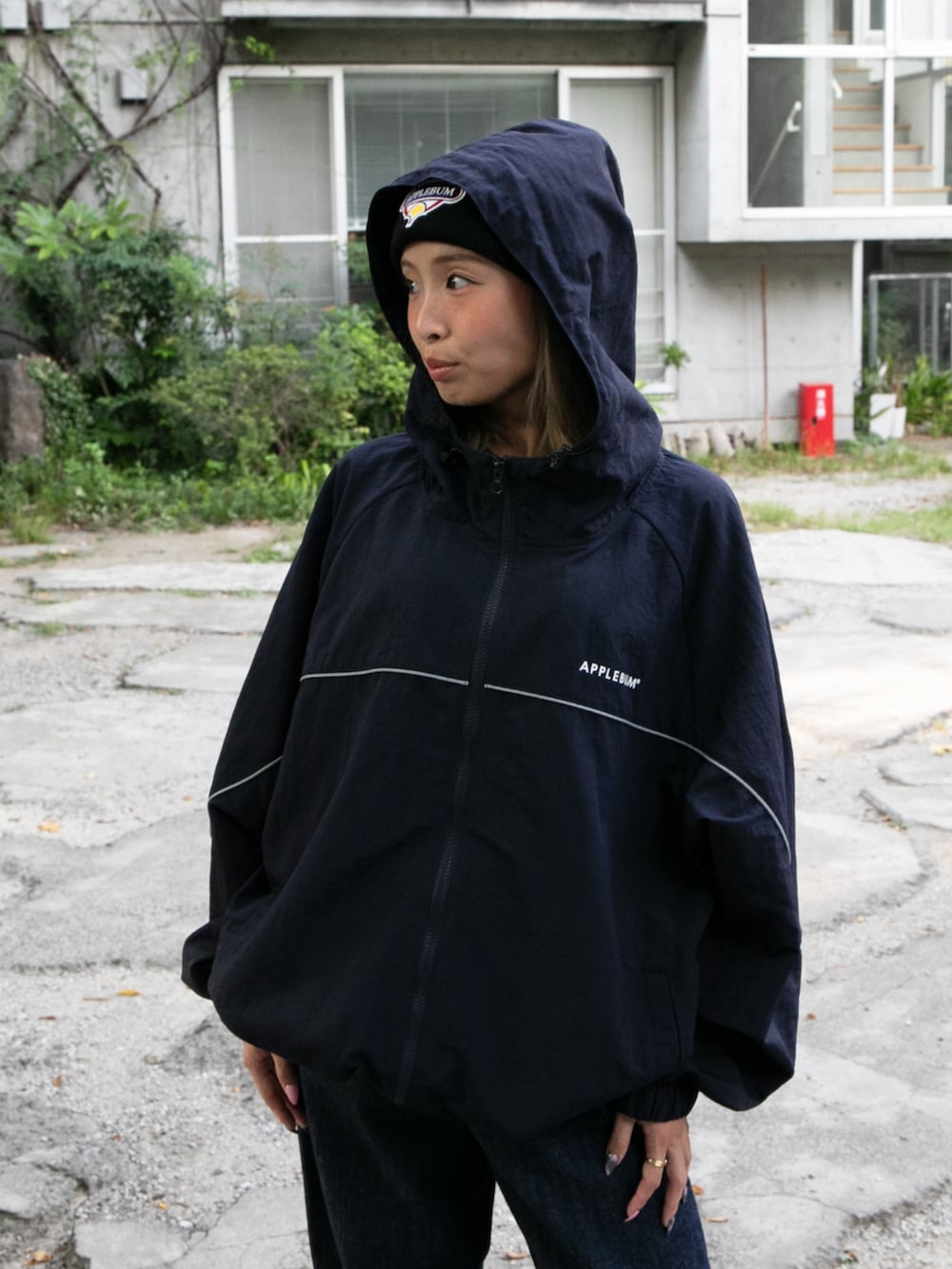 ブルー系のナイロンジャケット、ブラック系のニットキャップ/ビーニーを着用したレディースの秋コーディネートの2枚目の写真