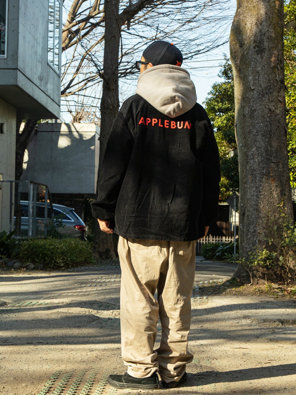 グレー系のパーカー、ブラック系のその他アウターを着用したメンズの春コーディネートの2枚目の写真