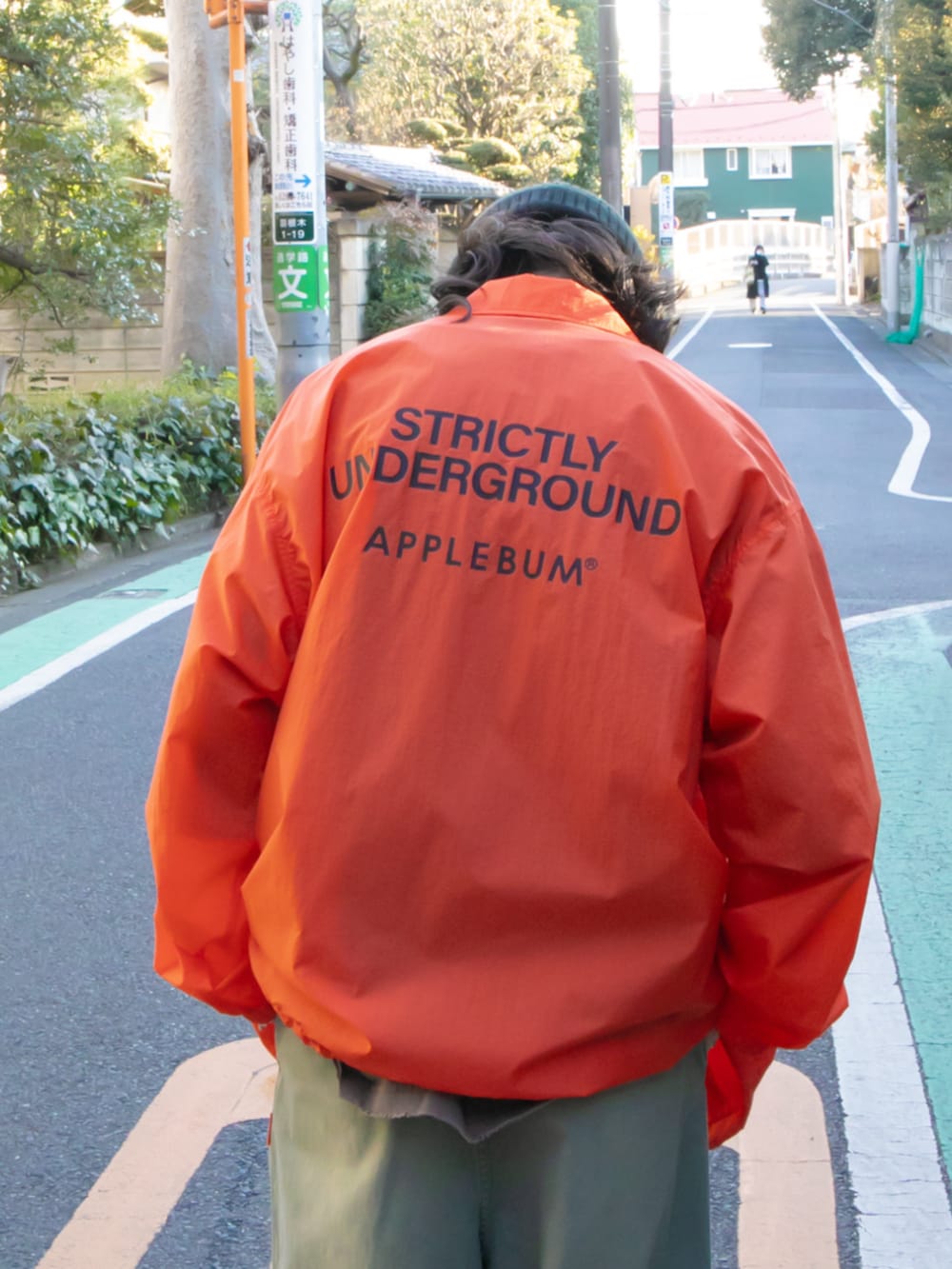 オレンジ系のブルゾン、ブラック系のその他パンツを着用したメンズの春コーディネートの4枚目の写真