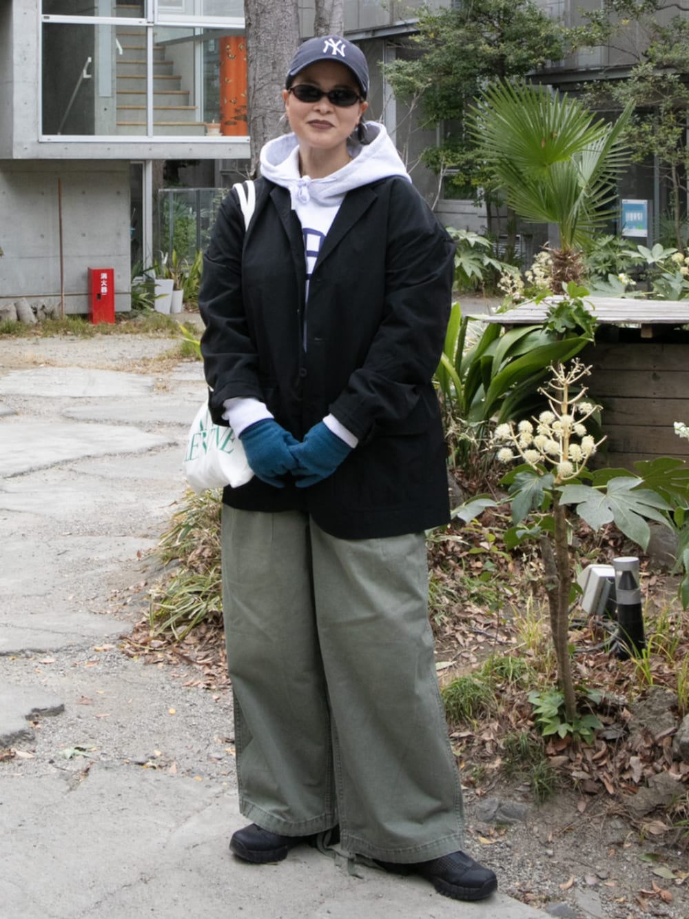 グレー系のパーカー、ブラック系のテーラードジャケットを着用したレディースの冬コーディネートの2枚目の写真