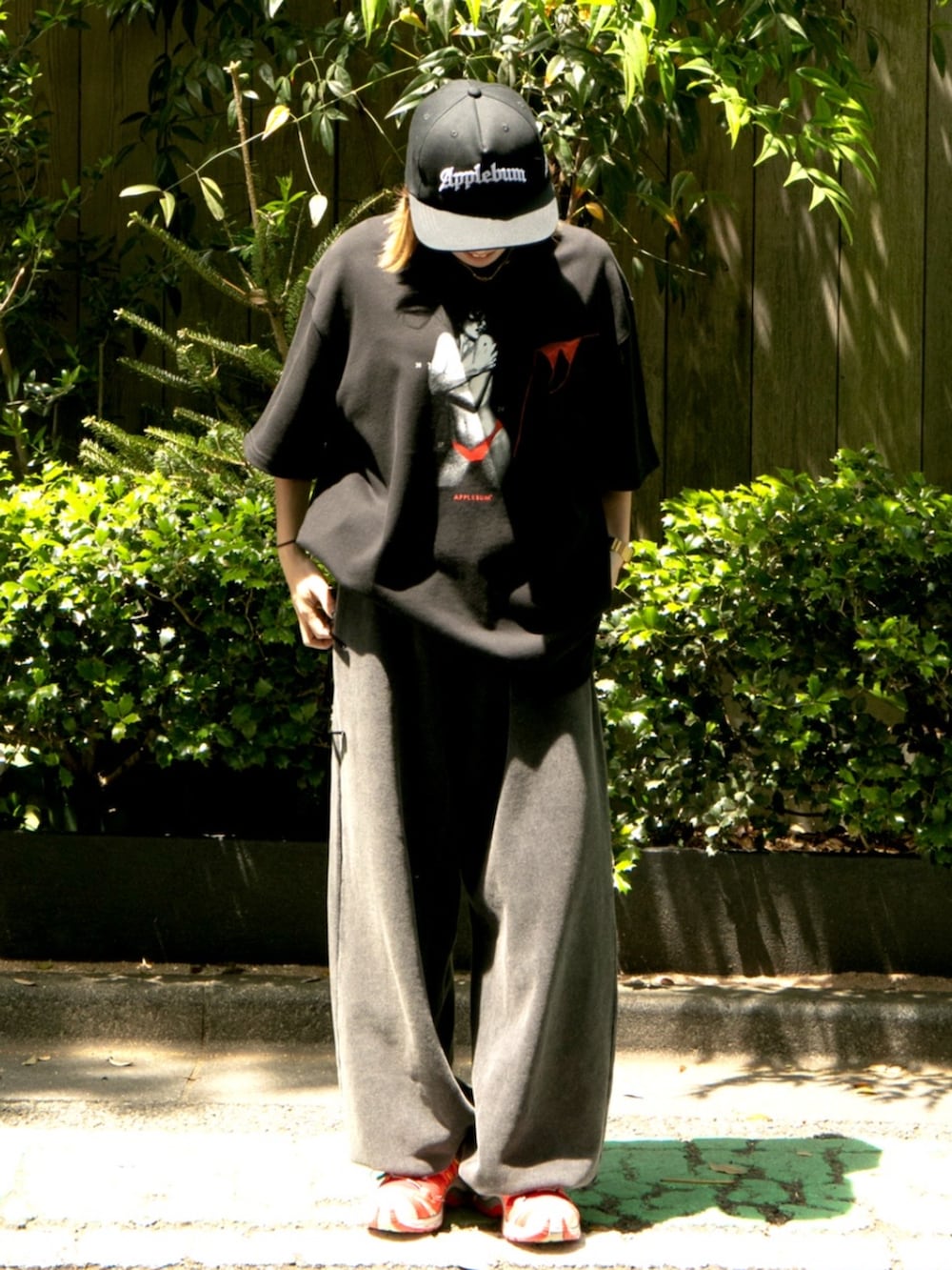 ブラック系のTシャツ/カットソー、ブラック系のスウェットパンツ、ブラック系のキャップを着用したレディースの夏コーディネートの2枚目の写真