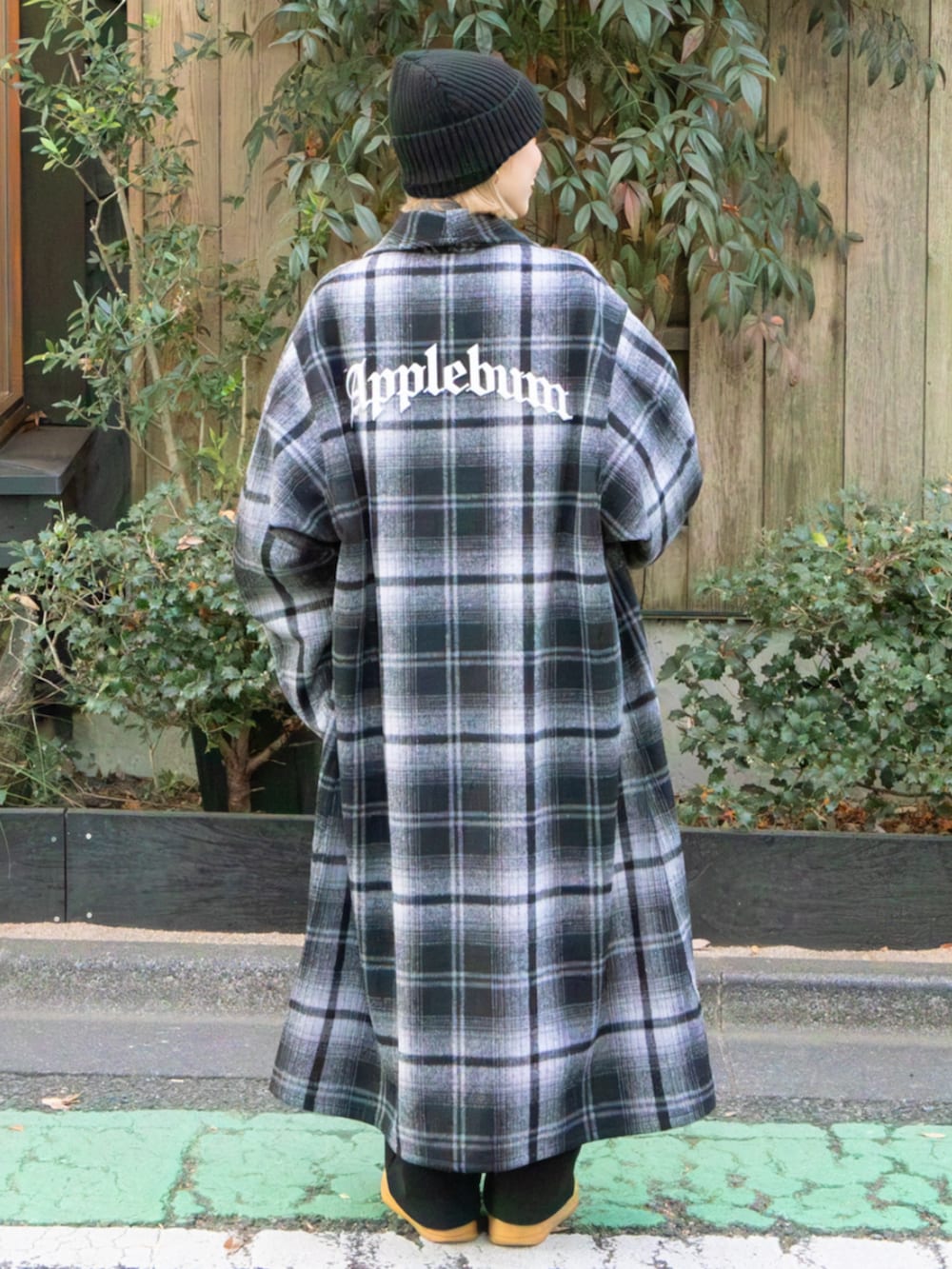 ブラック系のチェスターコート、ブラック系のニットキャップ/ビーニー、ブラック系のマフラーを着用したレディースの冬コーディネートの2枚目の写真