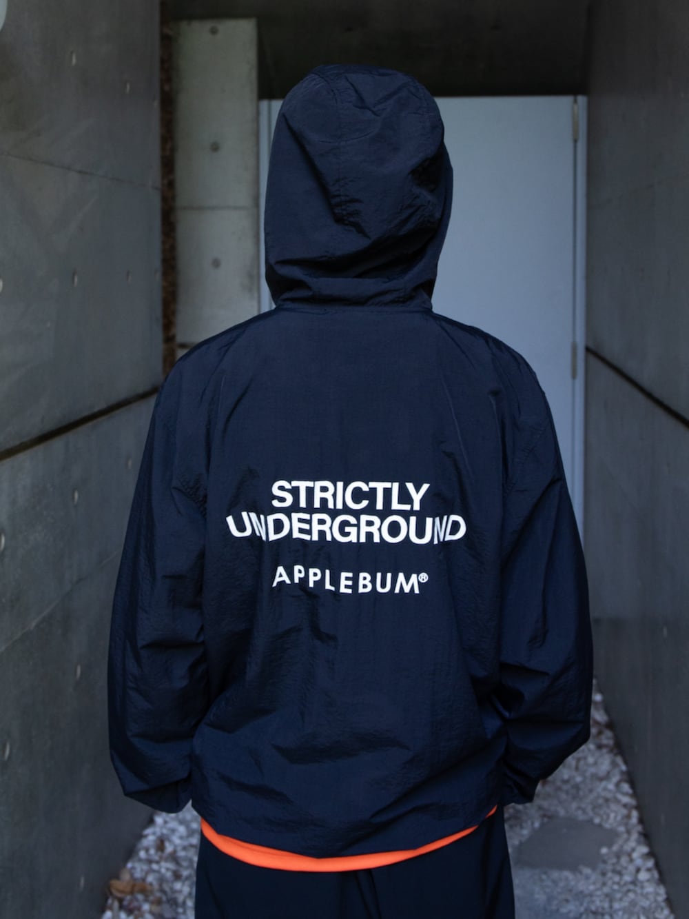 ブラック系のブルゾン、ブラック系のその他パンツ、オレンジ系のTシャツ/カットソーを着用したメンズの秋コーディネートの3枚目の写真