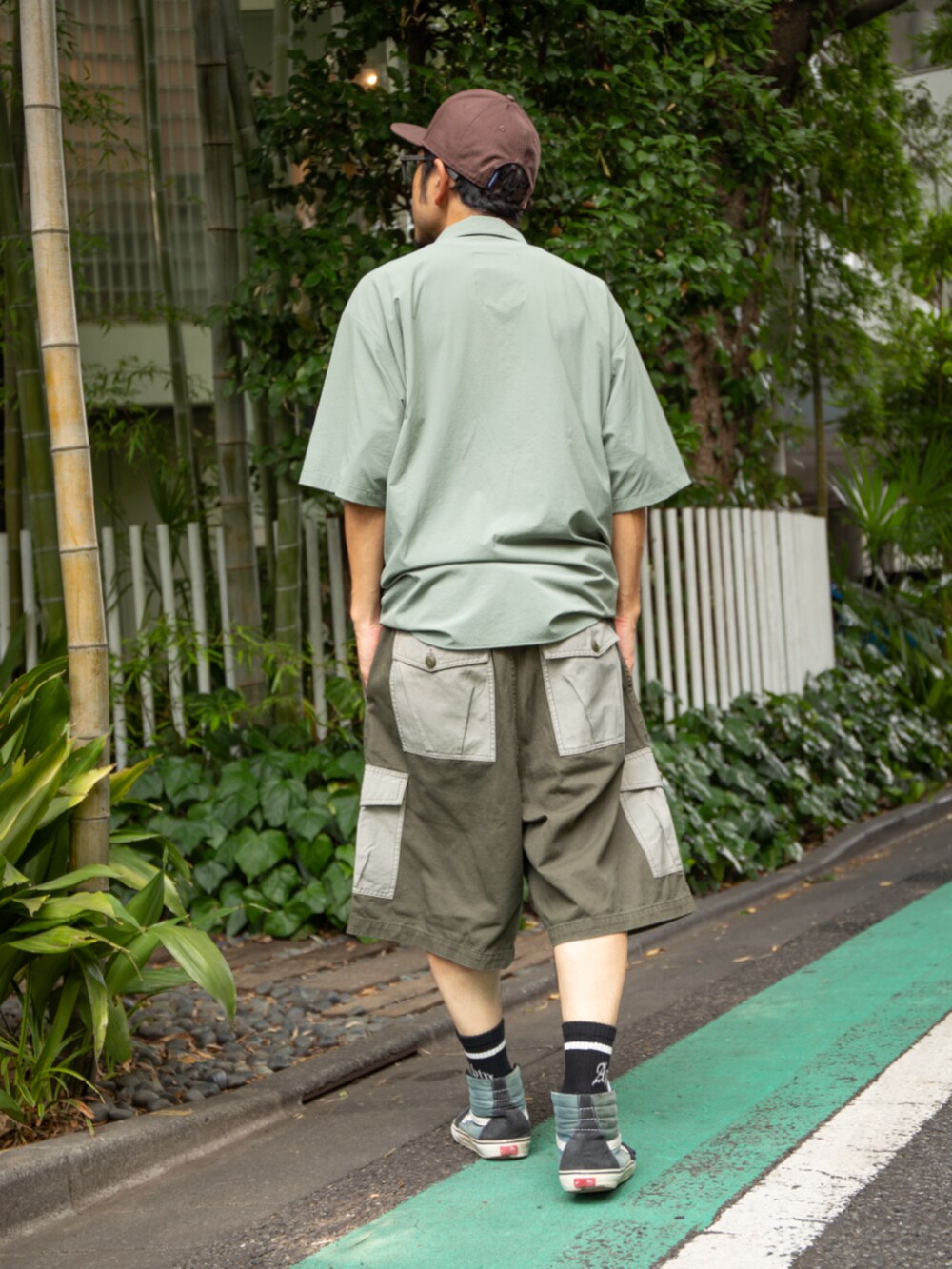 グリーン系のシャツ/ブラウス、グリーン系のカーゴパンツ、ブラウン系のキャップを着用したメンズの夏コーディネートの3枚目の写真