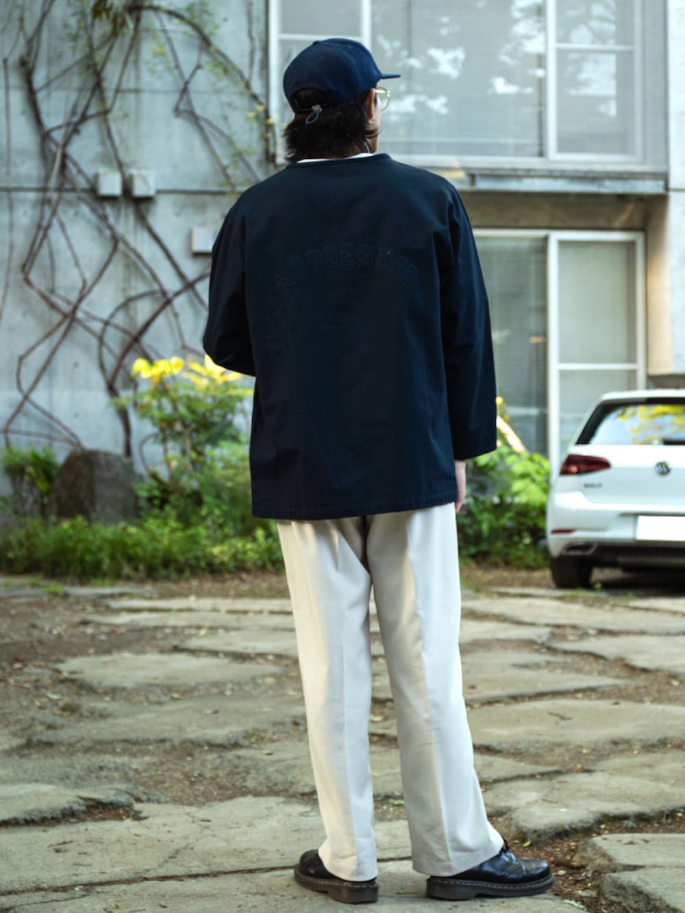 ブルー系のTシャツ/カットソー、ベージュ系のスラックス、ブルー系のキャップを着用したメンズの春コーディネートの2枚目の写真