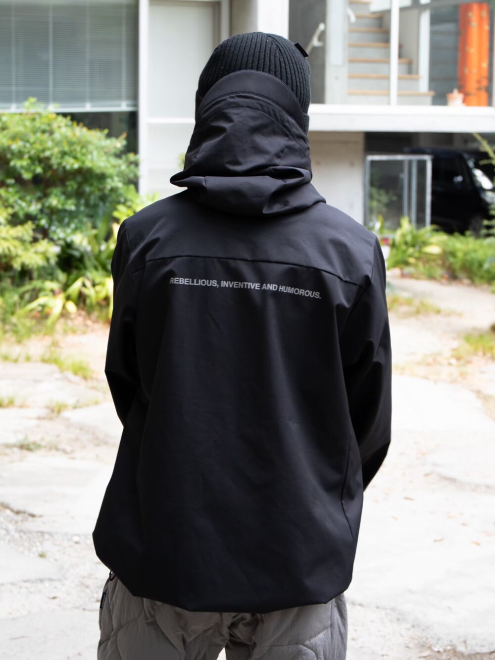 レッド系のTシャツ/カットソー、ブラック系のブルゾン、ブラック系のニットキャップ/ビーニーを着用したメンズの秋コーディネートの3枚目の写真