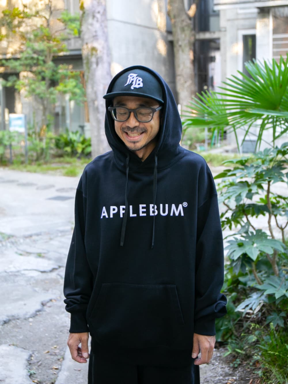 ブラック系のパーカー、ブラック系のデニムパンツ、ブラック系のキャップを着用したメンズの秋コーディネートの2枚目の写真