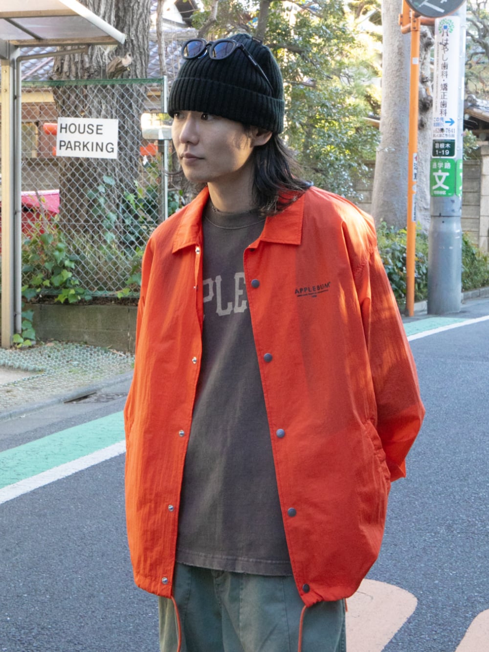 オレンジ系のブルゾン、ブラック系のその他パンツを着用したメンズの春コーディネートの3枚目の写真