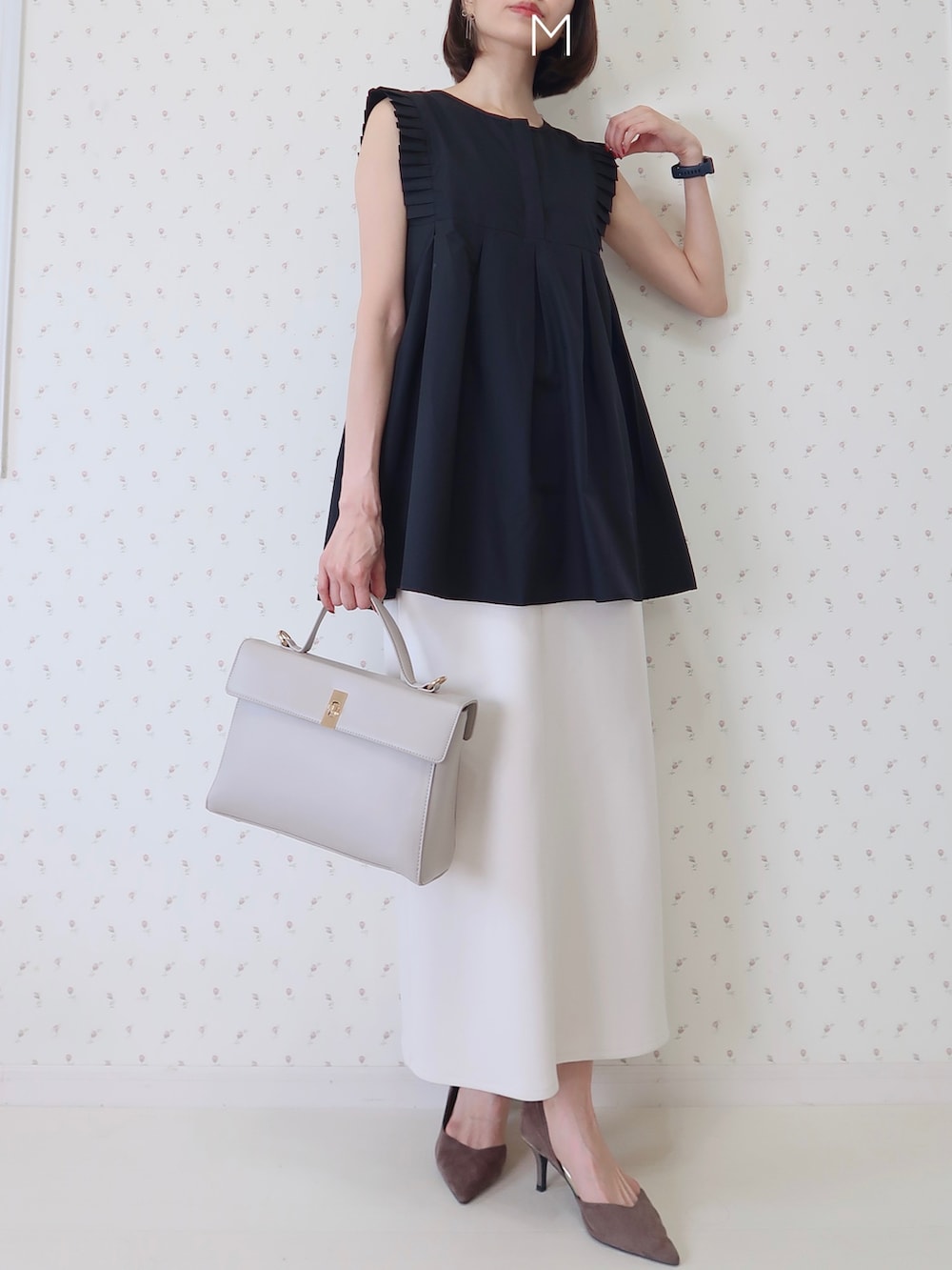 ブラック系のシャツ/ブラウス、ホワイト系のスカート、ベージュ系のハンドバッグを着用したレディースの夏コーディネートの2枚目の写真