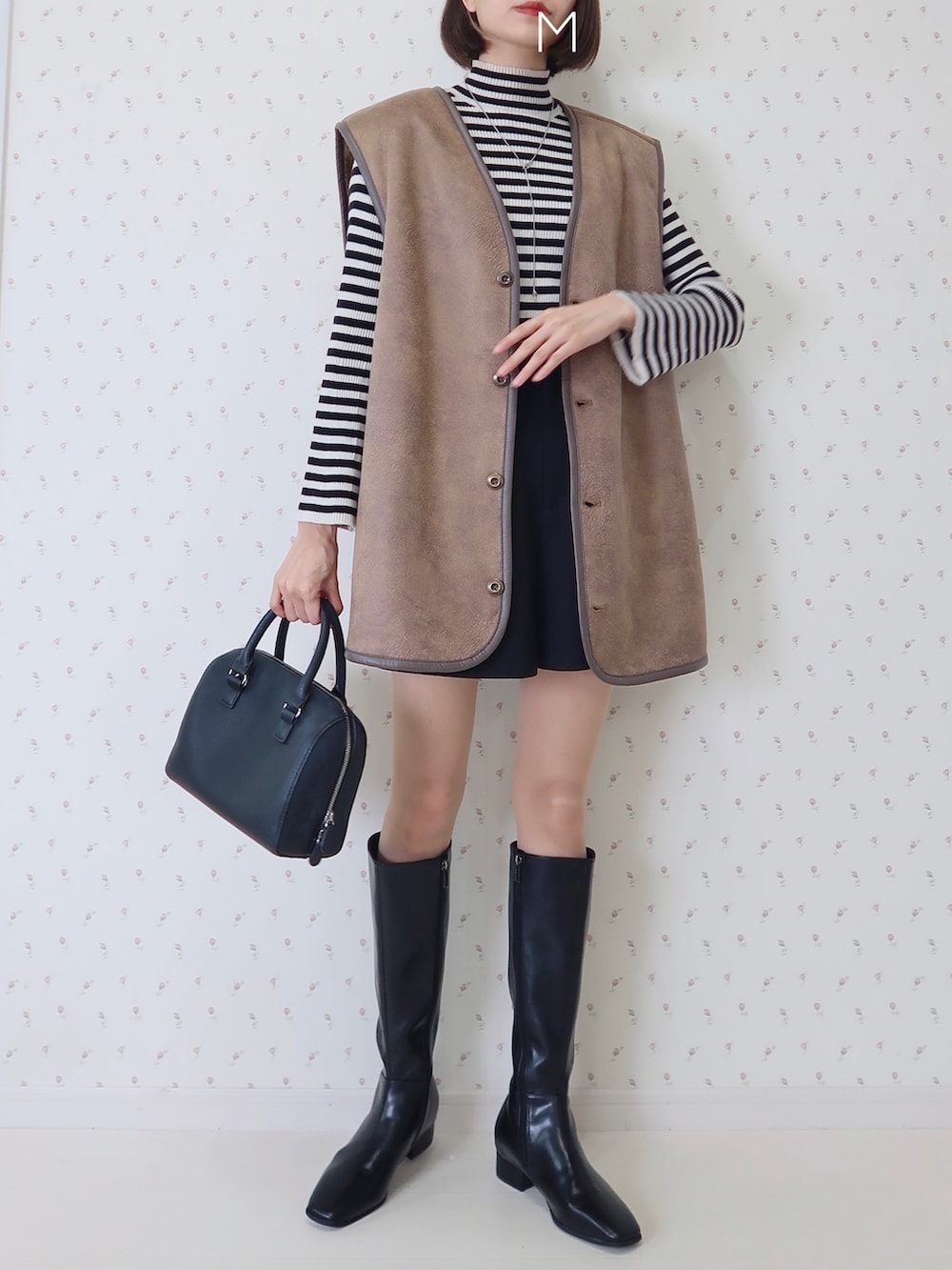 ブラウン系のベスト、ブラック系のブーツ、その他のニット/セーターを着用したレディースの秋コーディネートの2枚目の写真