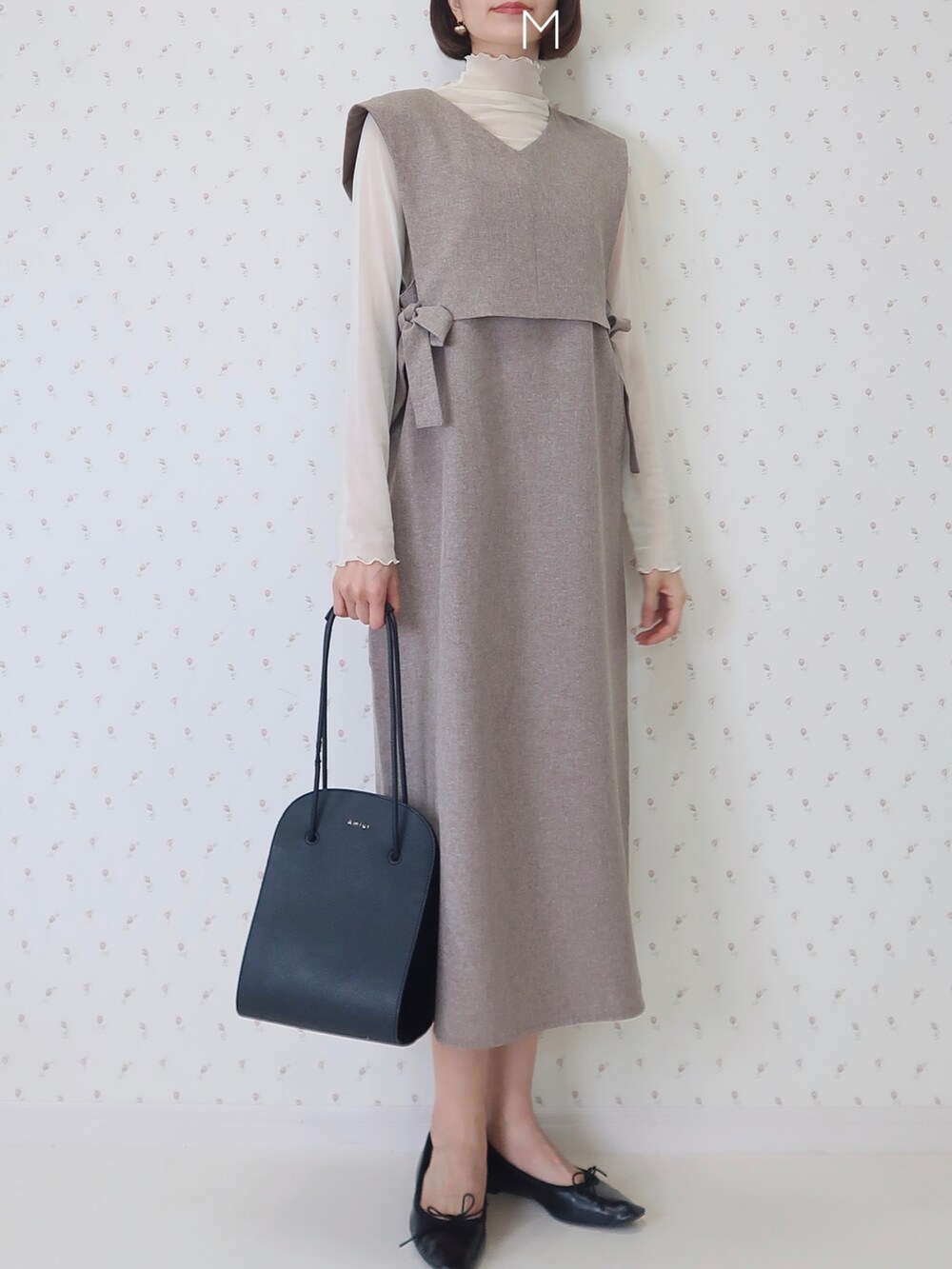 ブラック系のショルダーバッグ、ブラック系のバレエシューズ、ホワイト系のTシャツ/カットソーを着用したレディースの夏コーディネートの2枚目の写真