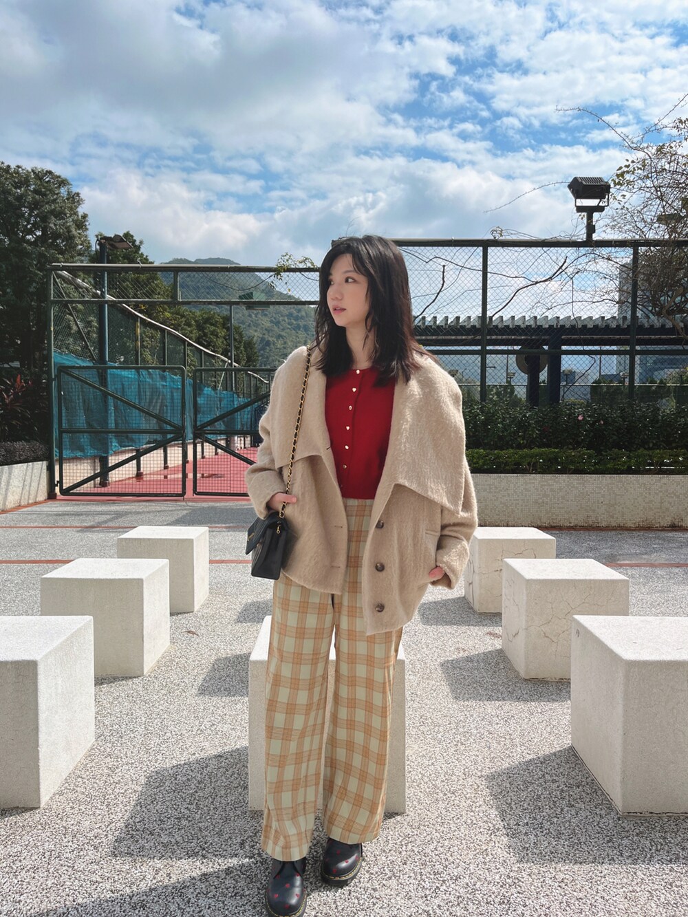 ブラック系のバッグ、ピンク系のカーディガン/ボレロ、ブラック系のシューズを着用したレディースの冬コーディネートの2枚目の写真